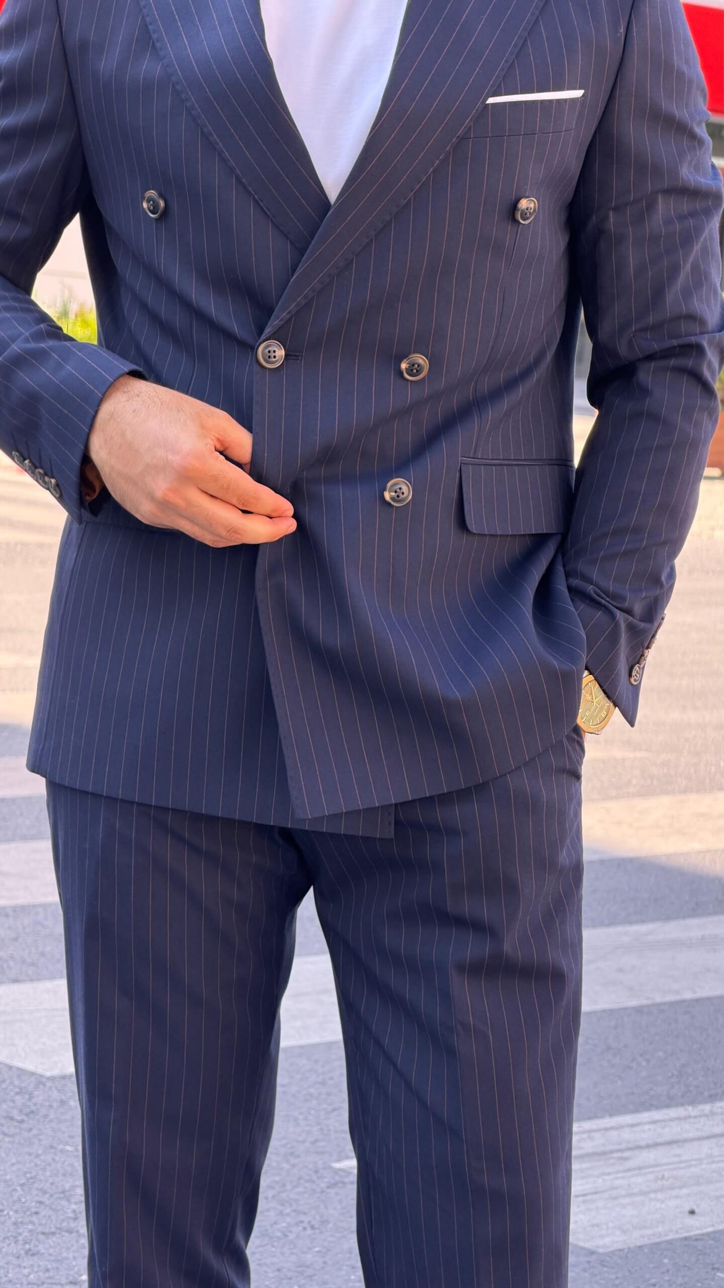 Men’s navy blue pinstripe double-breasted wool suit styled with white T-shirt and sneakers