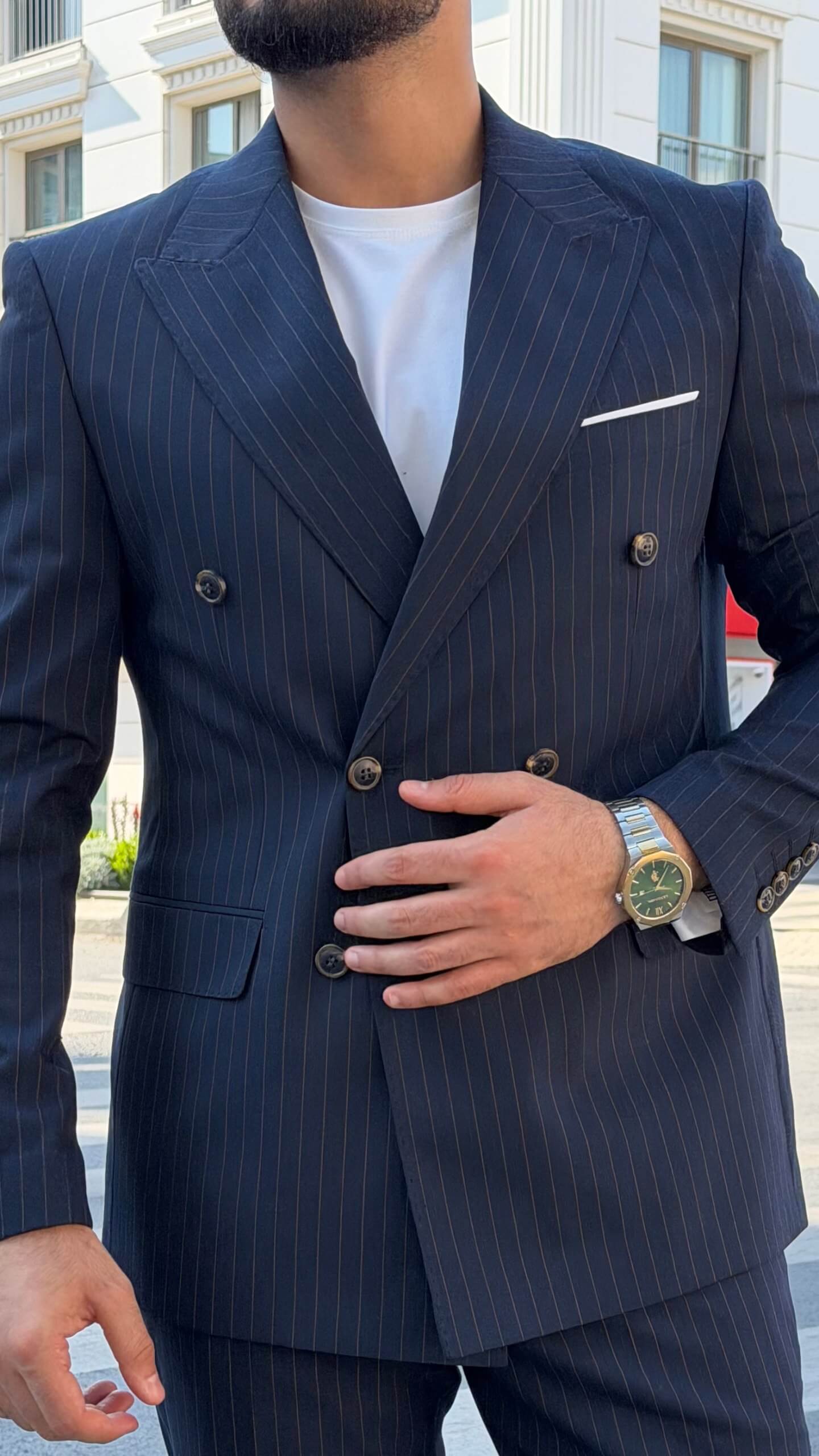 Men’s navy blue pinstripe double-breasted wool suit styled with white T-shirt and sneakers