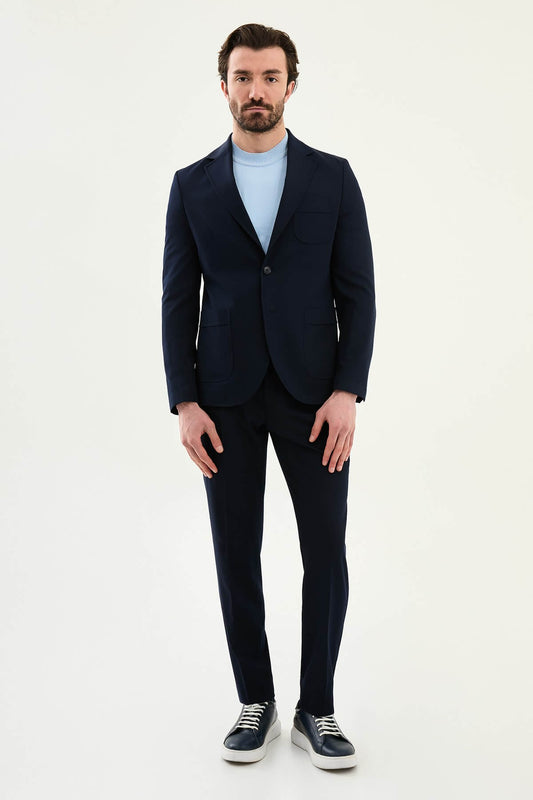 Men’s navy blue slim fit blazer with a clean modern design and stretch fabric, styled with a light blue knit top for elegant smart casual and formal occasions.