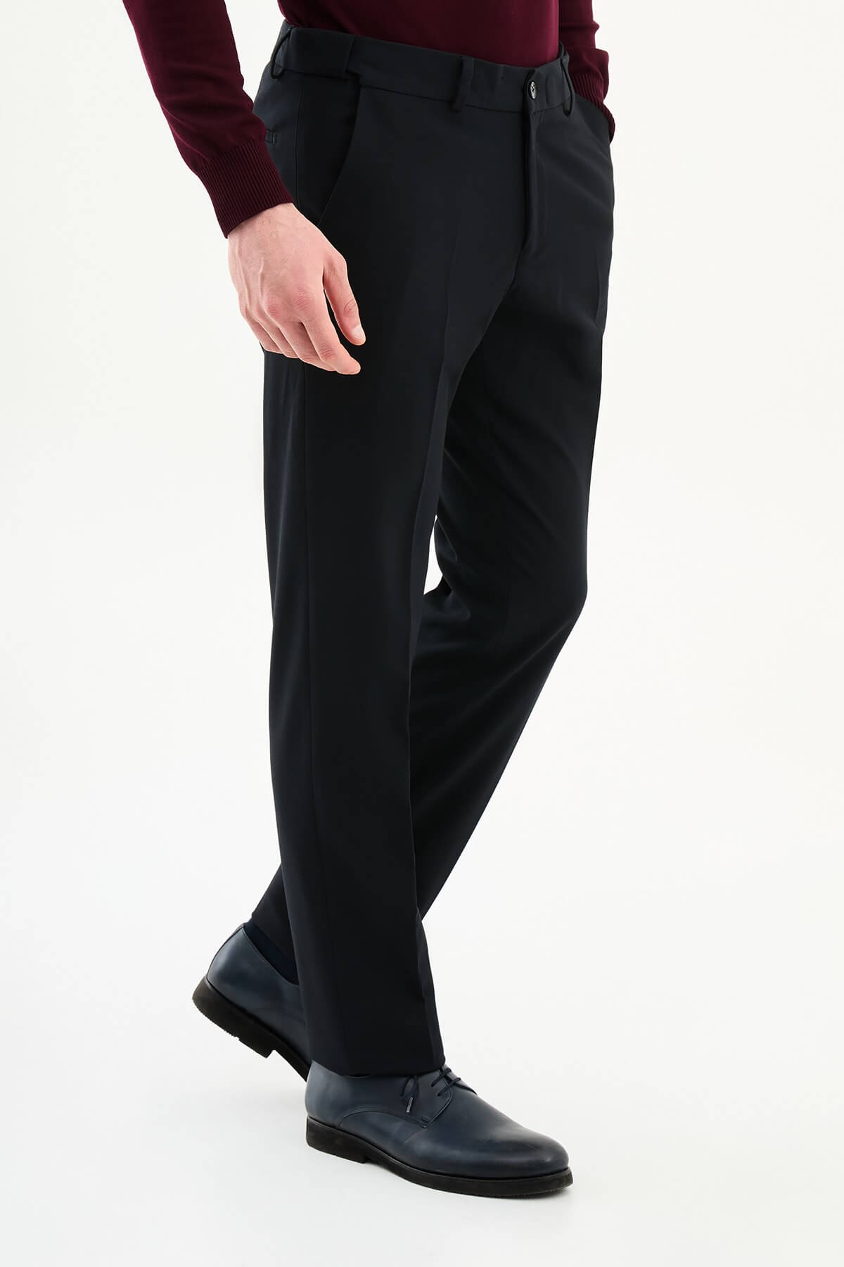Man wearing navy slim-fit dress trousers with a tailored fit, styled with black dress shoes and a burgundy shirt.