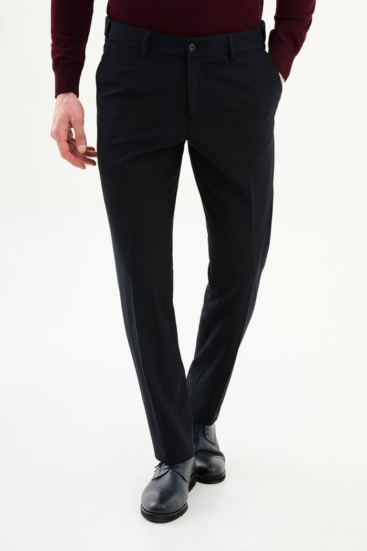 Man wearing navy slim-fit dress trousers with a tailored fit, styled with black dress shoes and a burgundy shirt.