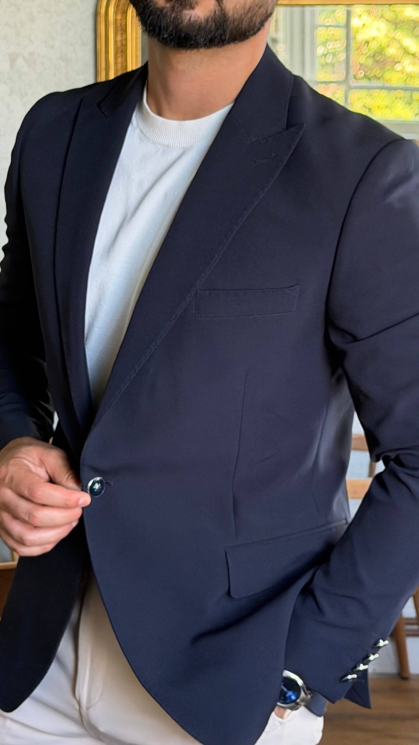 Men's navy blue slim fit blazer styled with white trousers