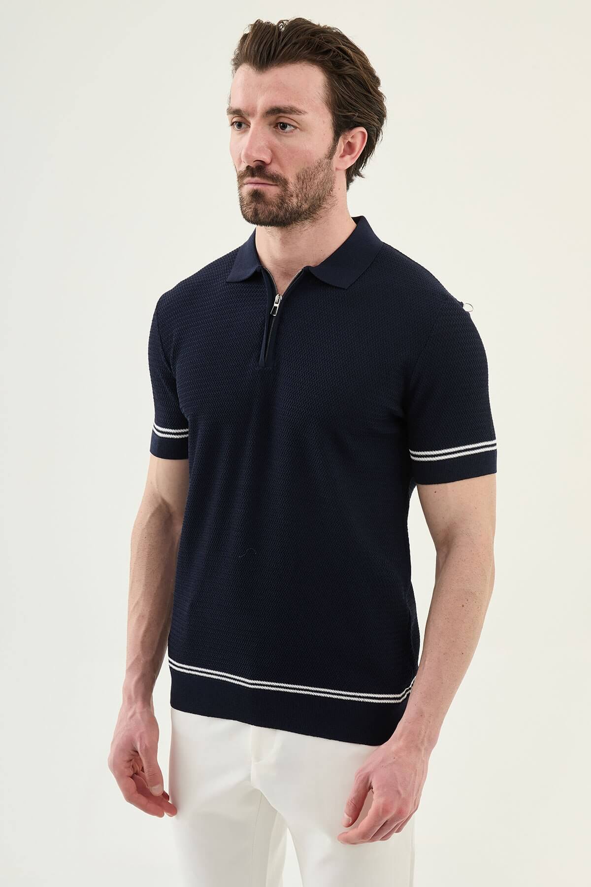 Man wearing navy blue slim-fit quarter-zip polo t-shirt with white stripe accents, paired with white trousers.