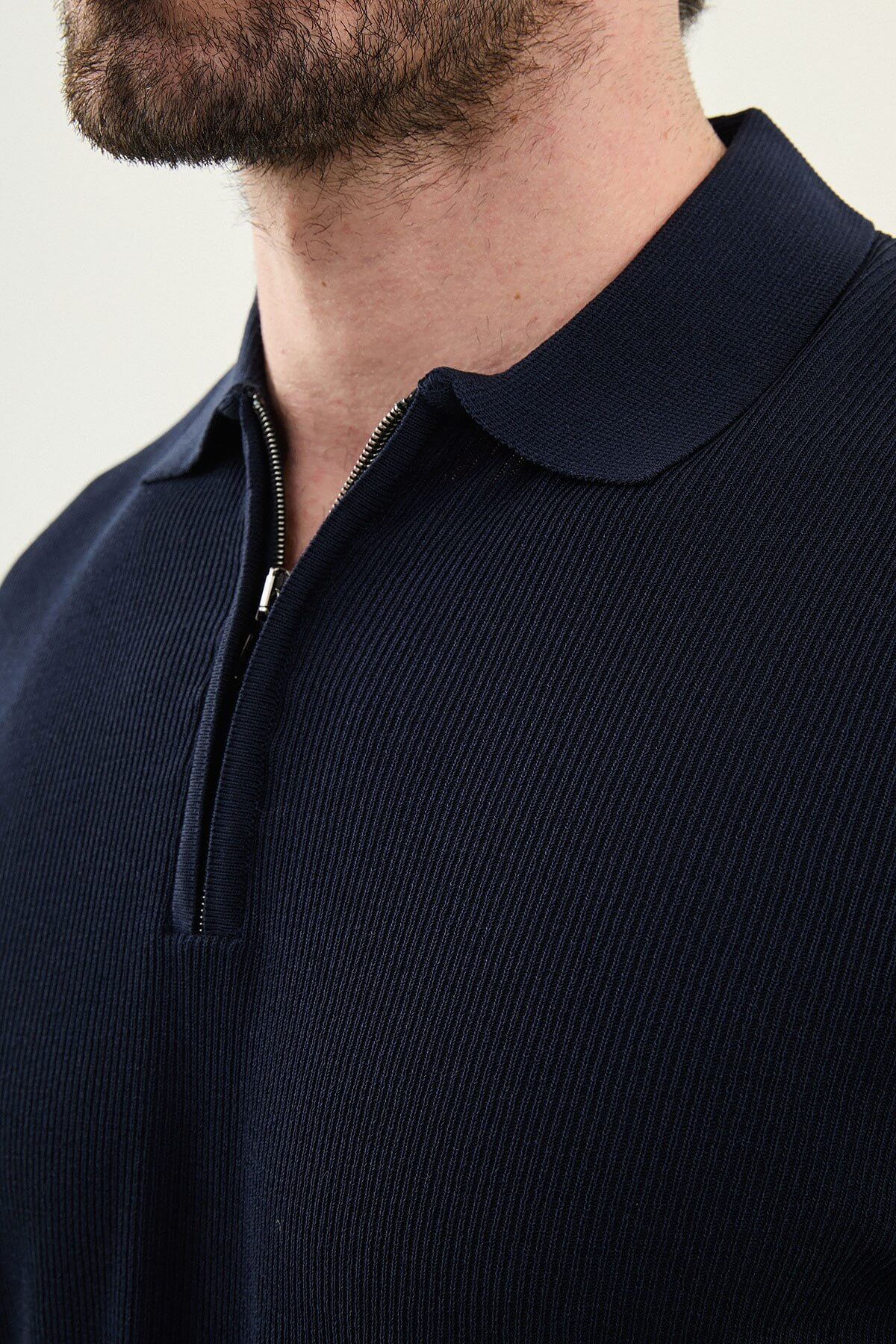 Men’s navy blue slim-fit knit polo shirt with classic collar, short sleeves, and textured knit finish for summer smart-casual style.