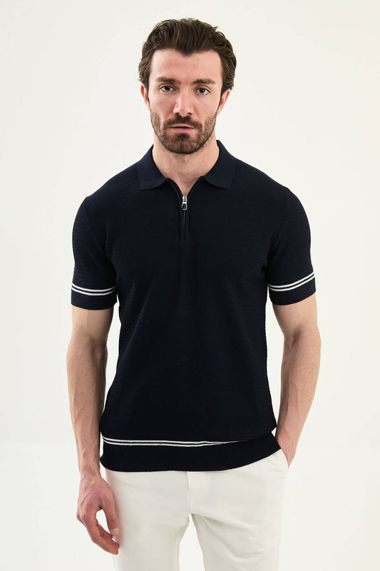 Man wearing navy blue slim-fit quarter-zip polo t-shirt with white stripe accents, paired with white trousers.