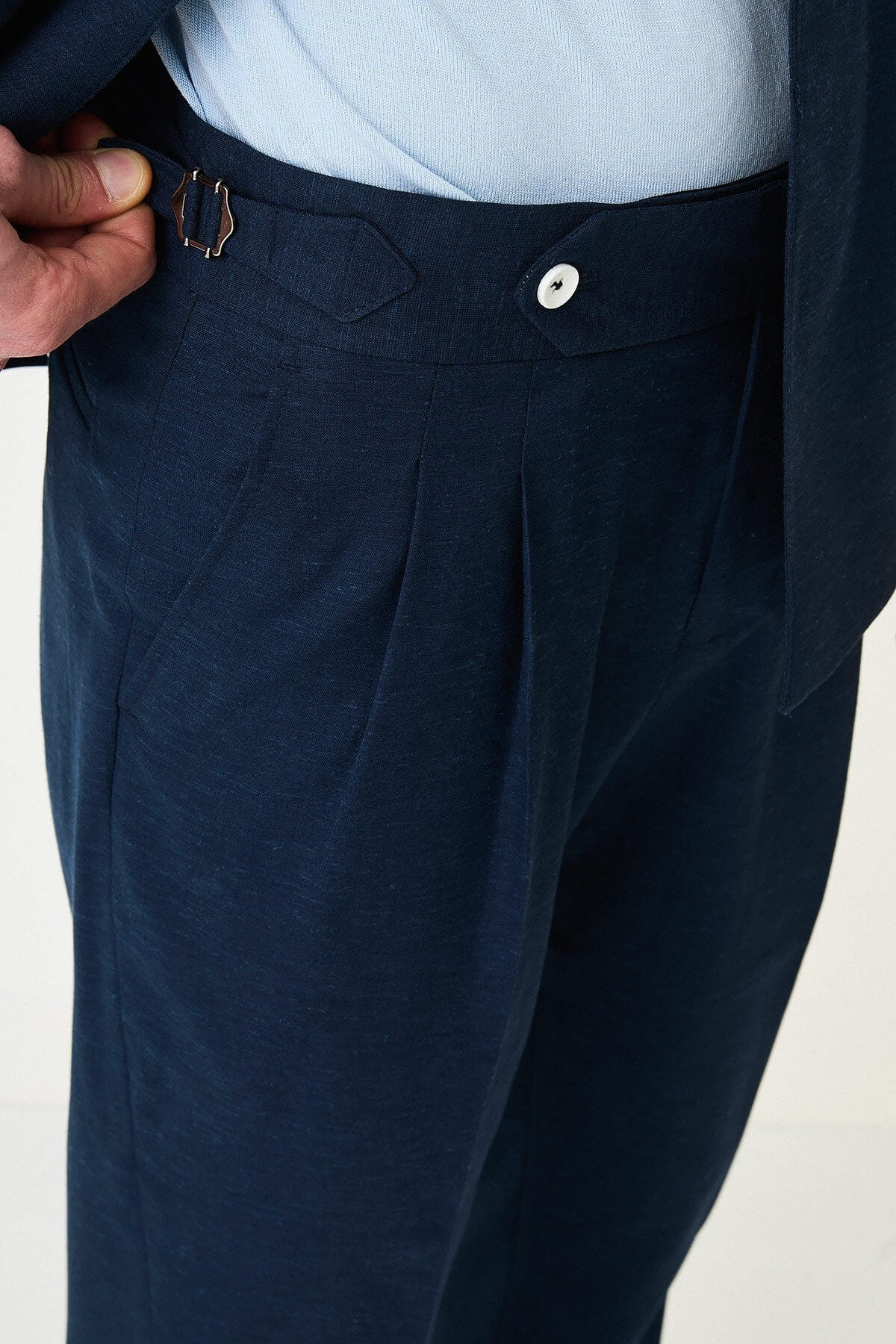 man wearing a Men’s Navy Blue Slim-fit Summer Suit, standing in a relaxed pose, showing the tailored double-breasted jacket and matching trousers.