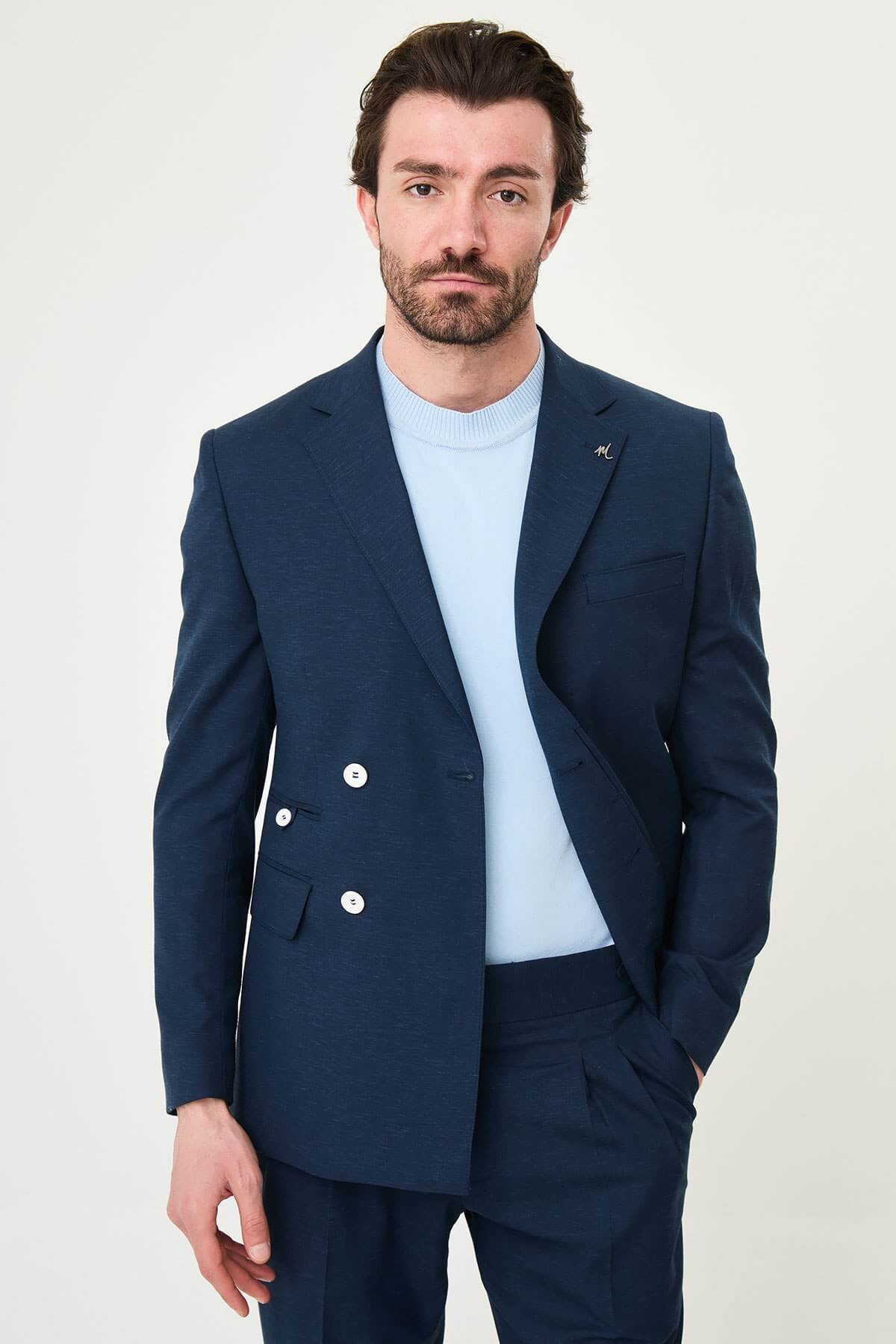 man wearing a Men’s Navy Blue Slim-fit Summer Suit, standing in a relaxed pose, showing the tailored double-breasted jacket and matching trousers.