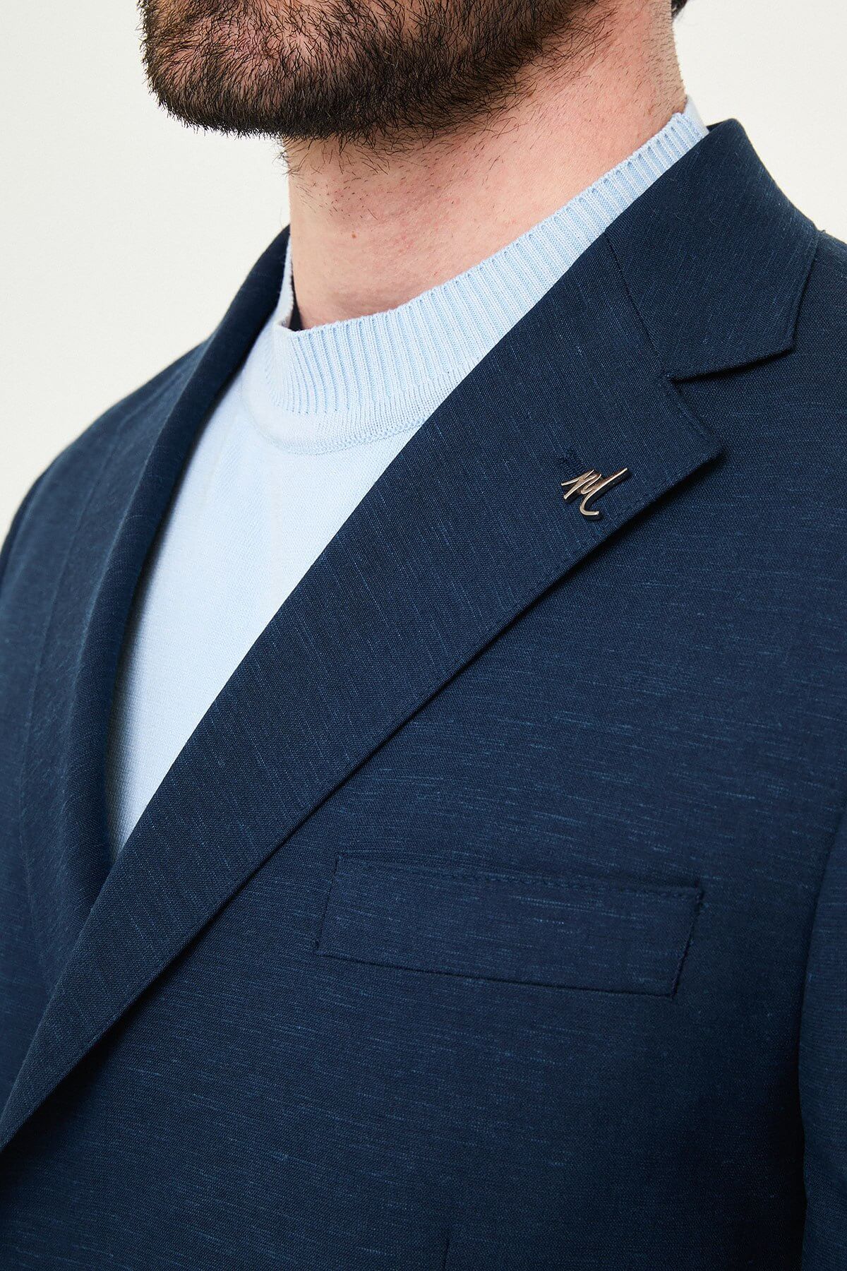 man wearing a Men’s Navy Blue Slim-fit Summer Suit, standing in a relaxed pose, showing the tailored double-breasted jacket and matching trousers.