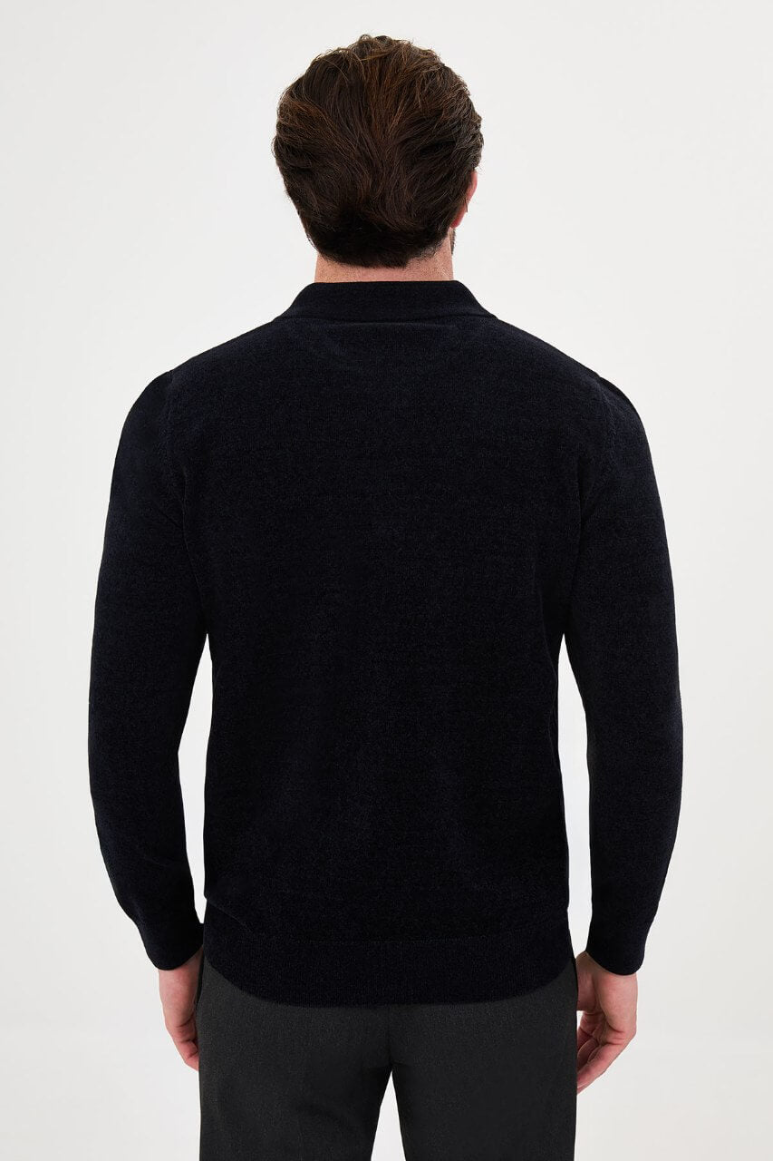 Men’s navy blue polo neck knit sweater with zip collar detail styled with dark trousers for a refined fall winter smart-casual outfit.