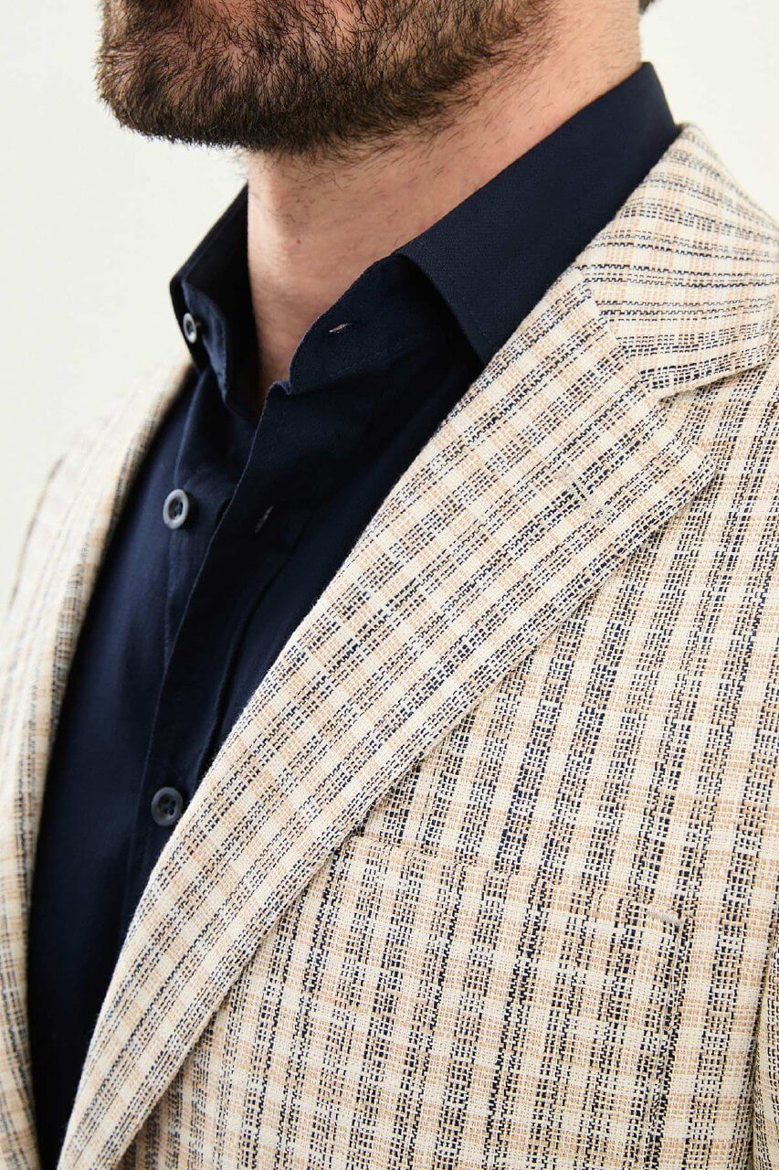 Men’s navy blue slim fit cotton linen blazer with a lightweight textured pattern, styled for elegant smart casual and summer occasions.