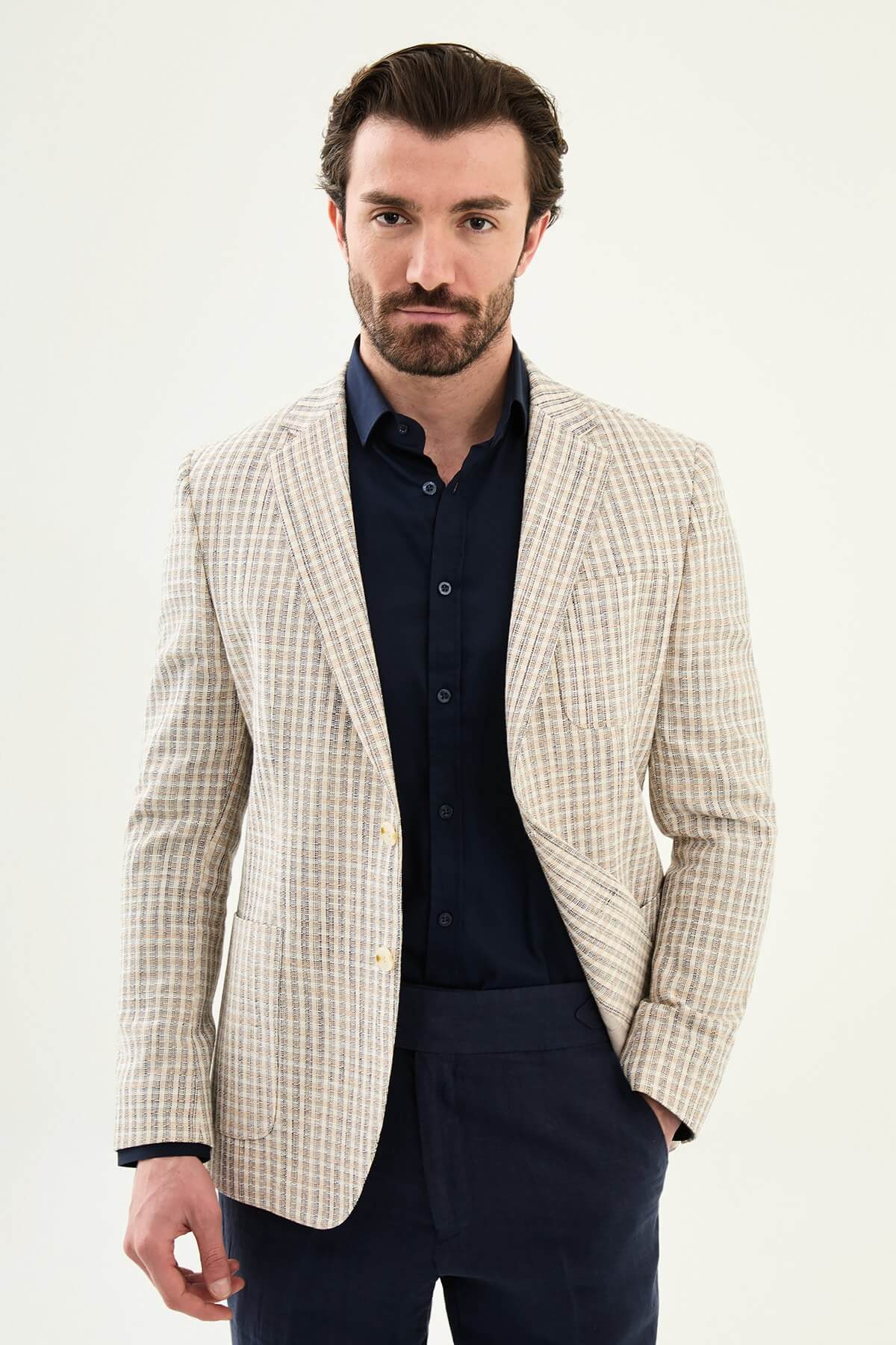 Men’s navy blue slim fit cotton linen blazer with a lightweight textured pattern, styled for elegant smart casual and summer occasions.