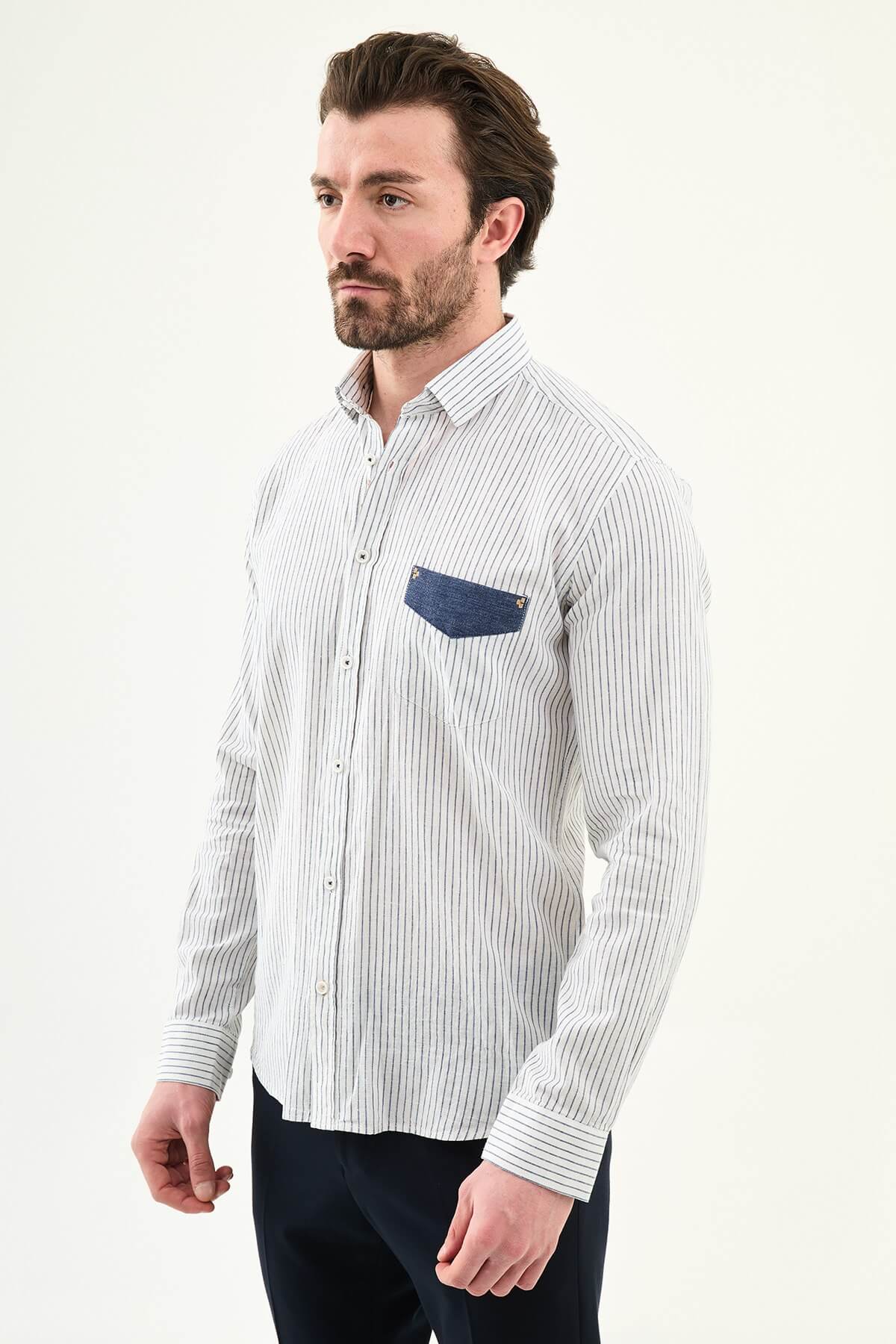 Men wearing a navy blue slim-fit long sleeve shirt with contrast pocket, styled in casual smart summer outfit.