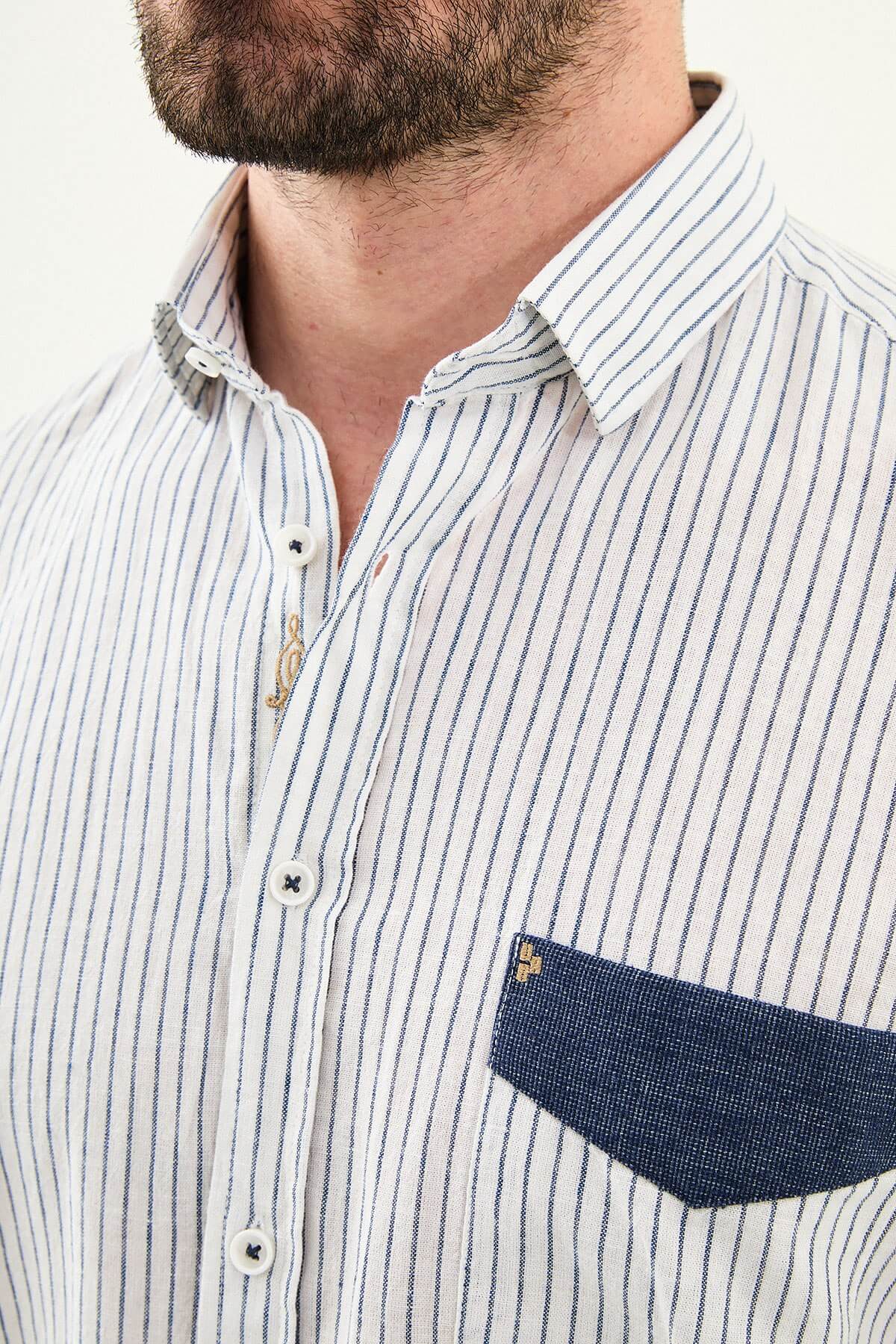 Men wearing a navy blue slim-fit long sleeve shirt with contrast pocket, styled in casual smart summer outfit.