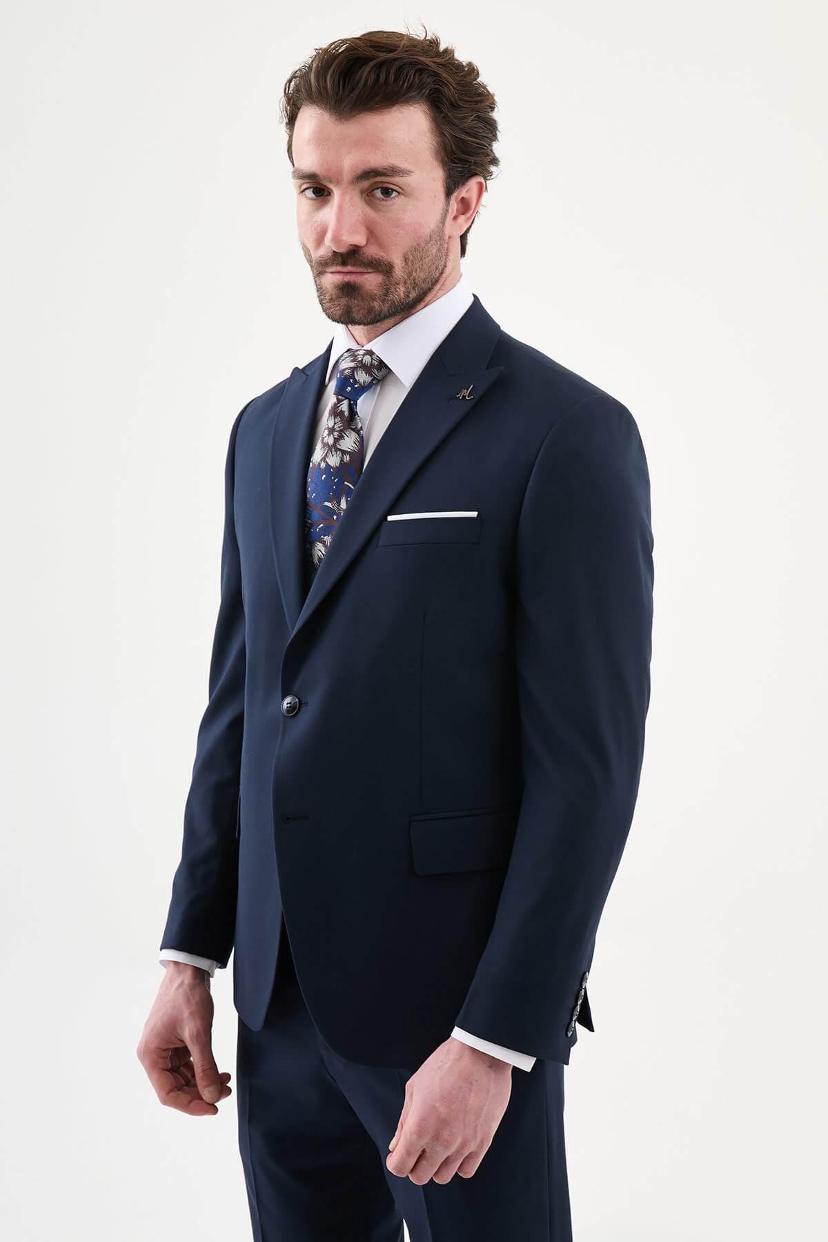 man wearing a navy blue slim-fit three-piece suit, including blazer, vest, and trousers, styled with a white shirt and tie, suitable for summer weddings and business events.