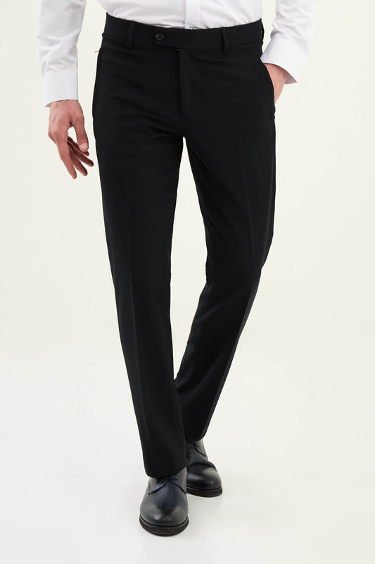 Man wearing navy blue slim-fit dress trousers styled with a white shirt and black leather shoes.