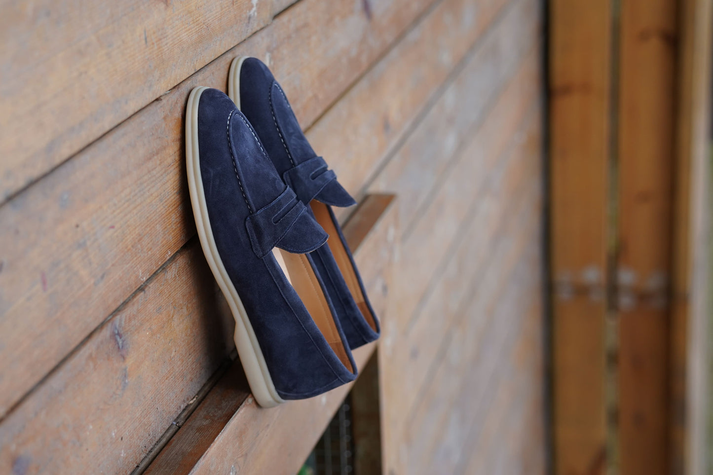 Men’s navy blue suede leather penny loafers with classic vamp strap and lightweight sole.