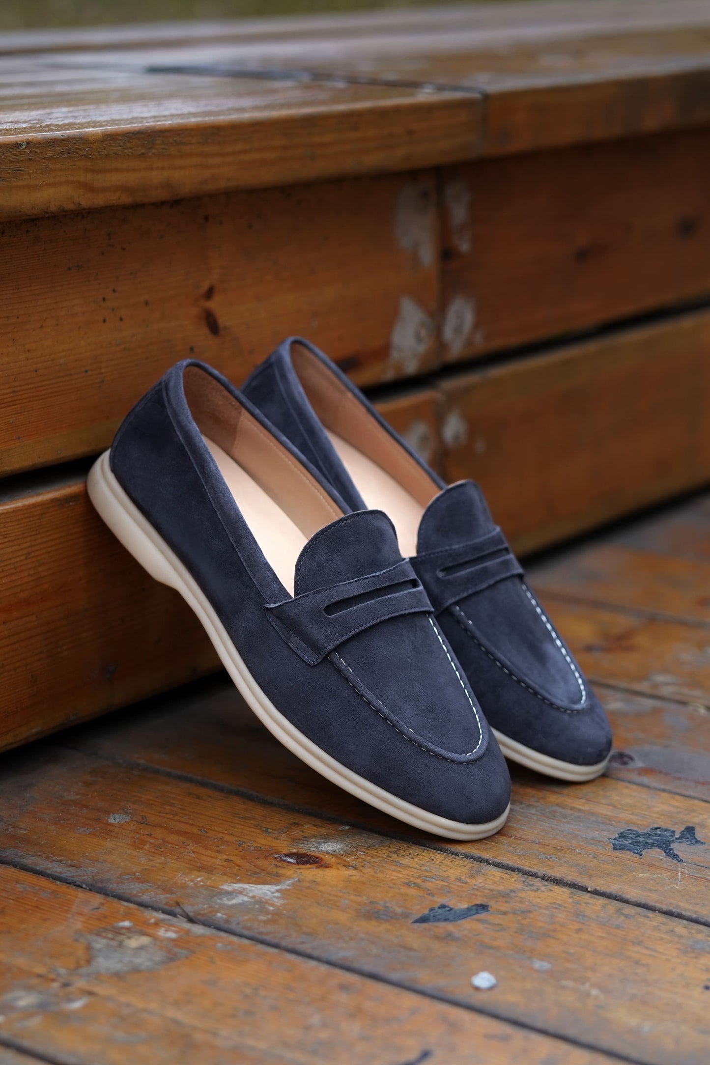 Men’s navy blue suede leather penny loafers with classic vamp strap and lightweight sole.