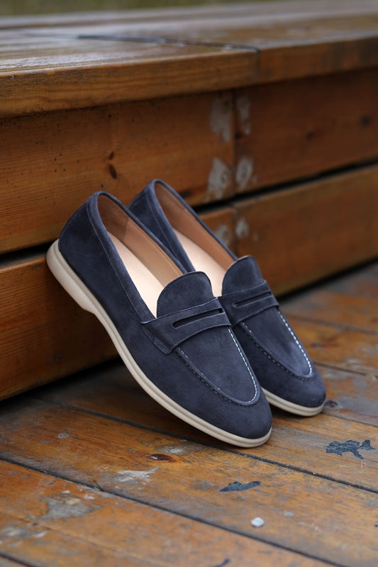 Men’s navy blue suede leather penny loafers with classic vamp strap and lightweight sole.