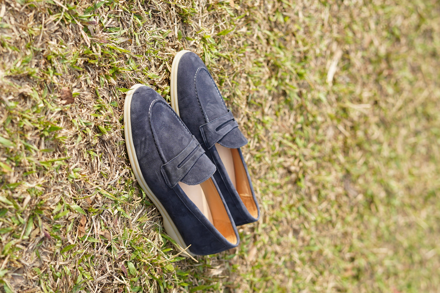 Men’s navy blue suede leather penny loafers with classic vamp strap and lightweight sole.