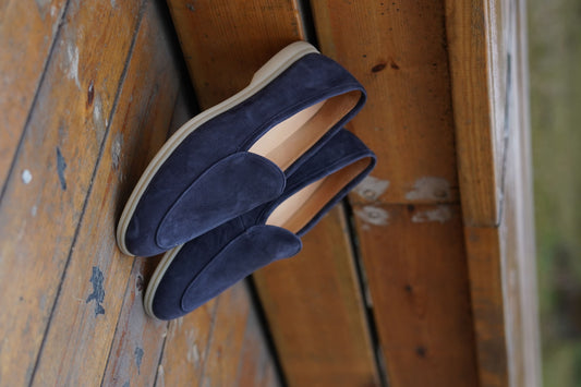 Men’s navy blue suede slip-on loafers featuring a minimalist design and cream sole, styled for elegant summer smart-casual outfits.