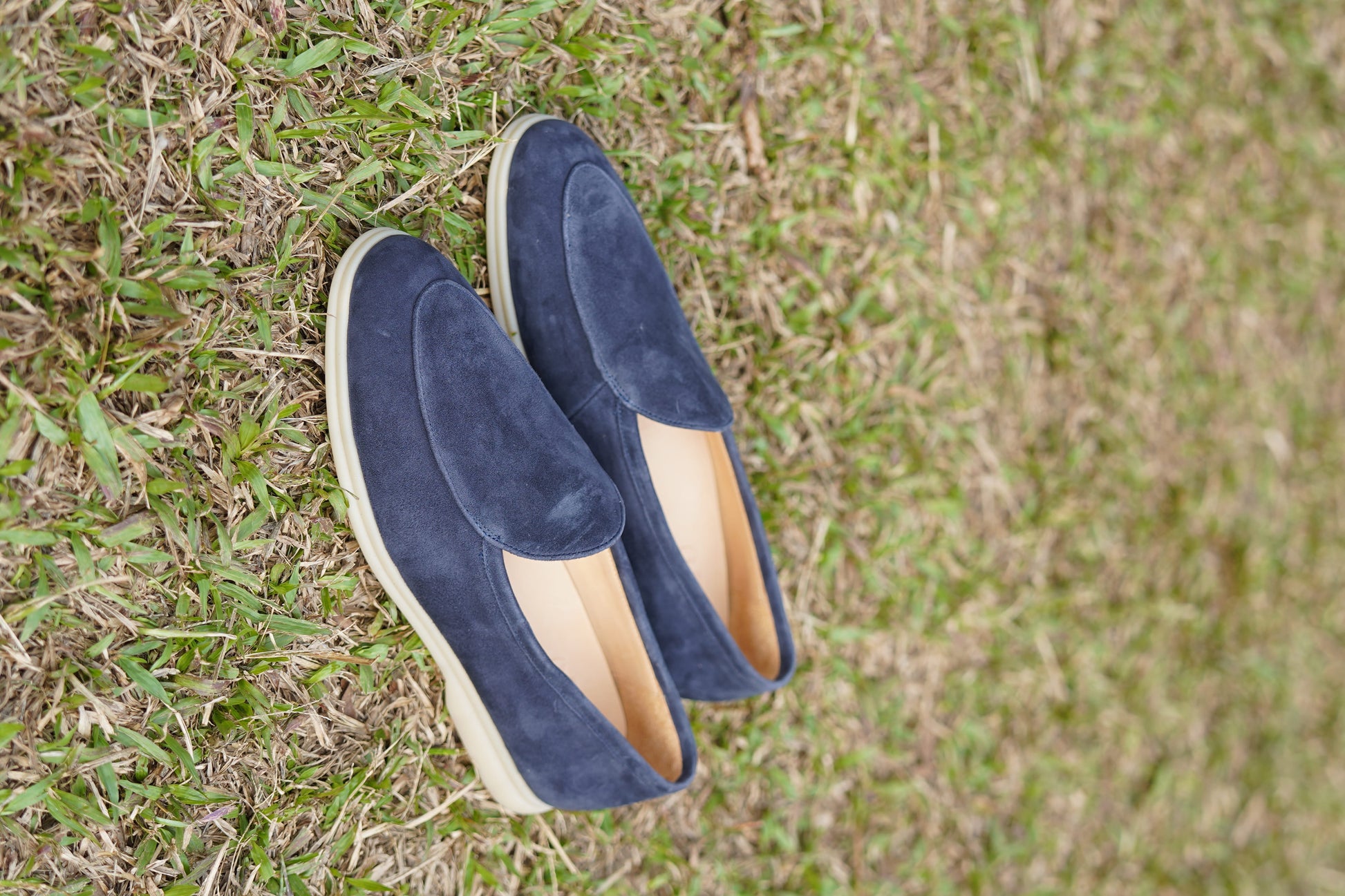 Men’s navy blue suede slip-on loafers featuring a minimalist design and cream sole, styled for elegant summer smart-casual outfits.