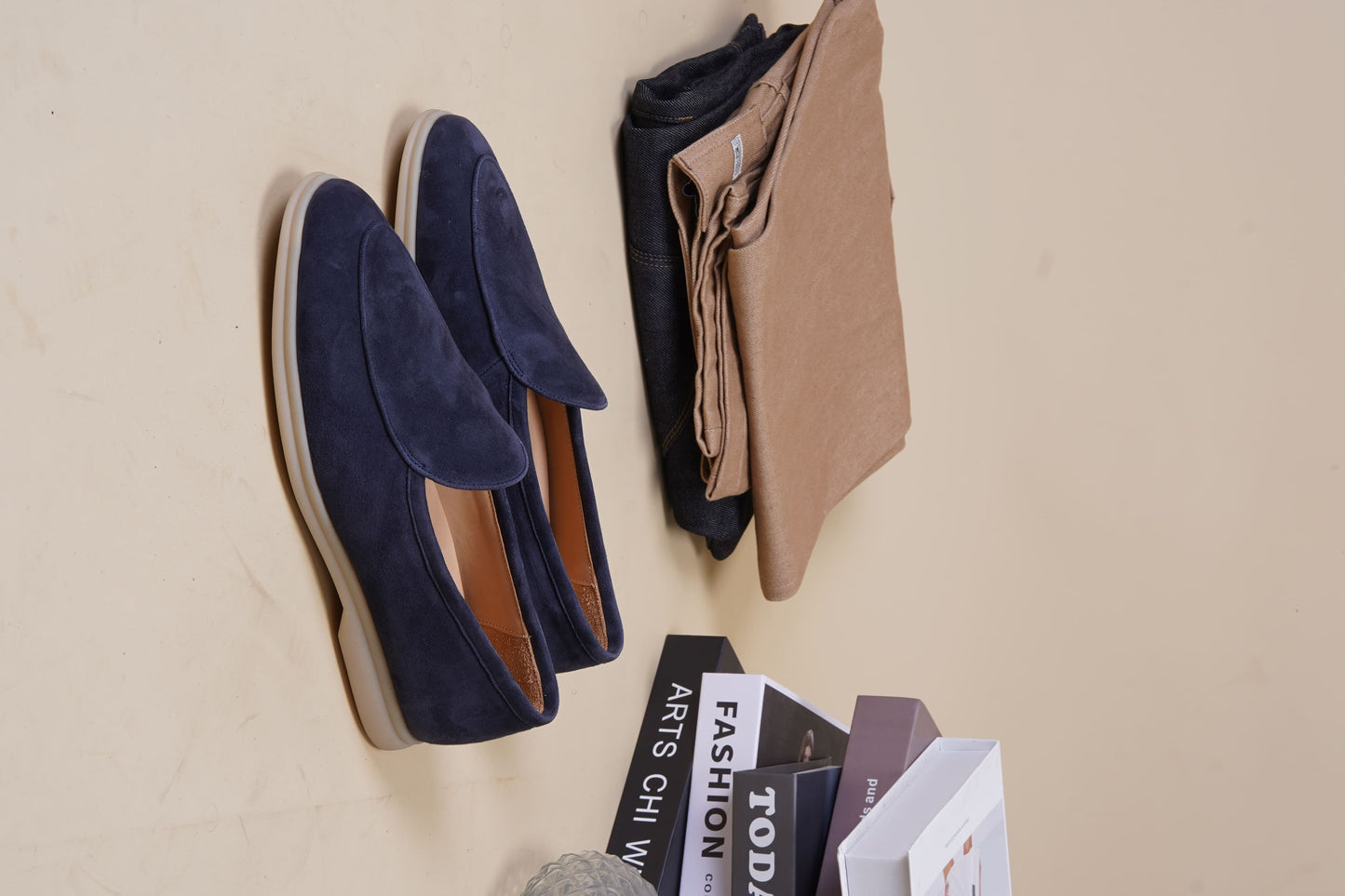 Men’s navy blue suede slip-on loafers featuring a minimalist design and cream sole, styled for elegant summer smart-casual outfits.