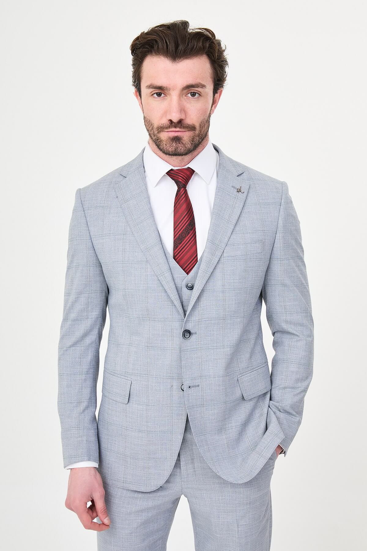 a navy blue slim-fit three-piece suit with a subtle windowpane check, matching waistcoat and trousers, white dress shirt, burgundy striped tie, and black leather Derby shoes.