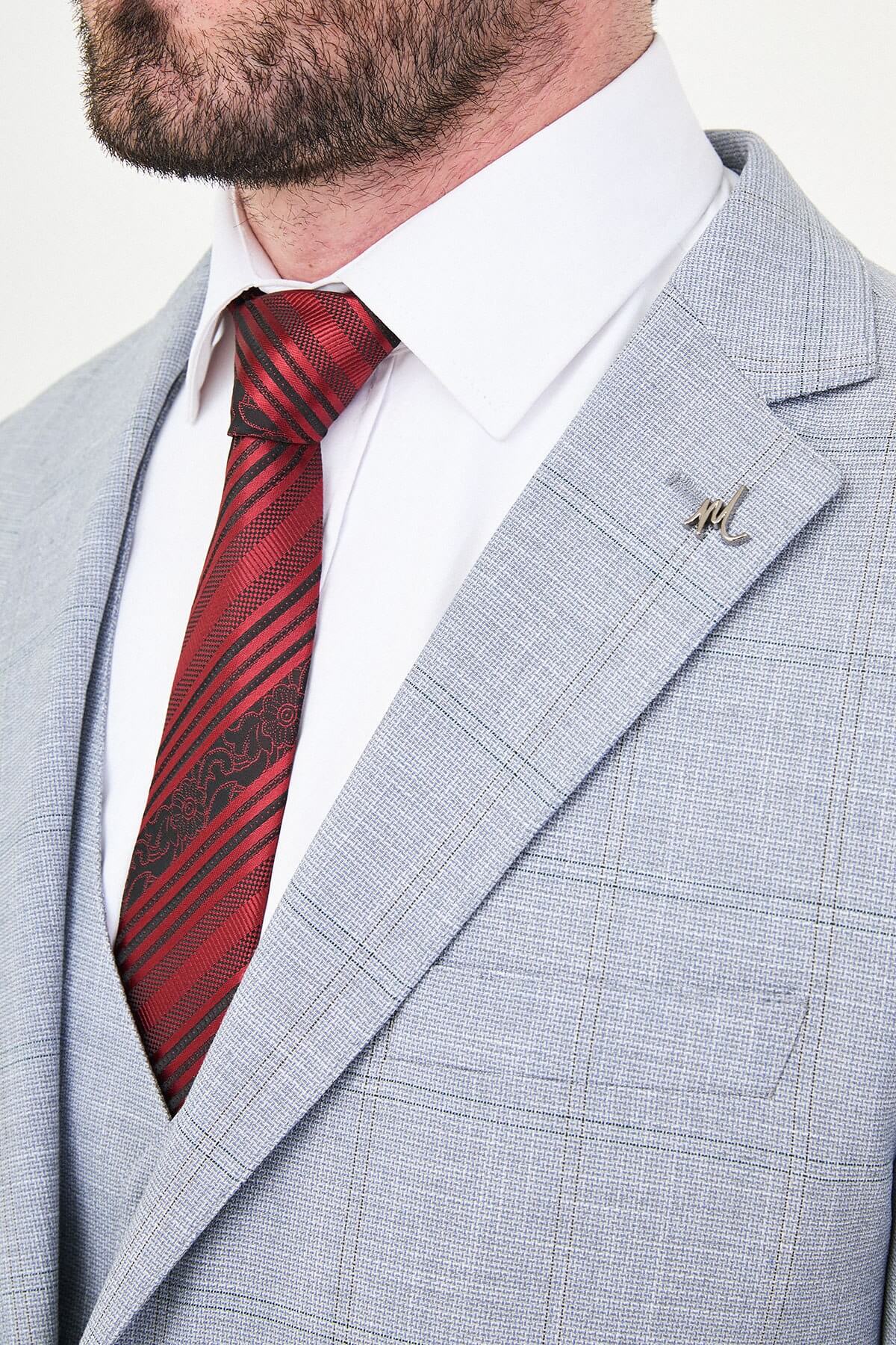 a navy blue slim-fit three-piece suit with a subtle windowpane check, matching waistcoat and trousers, white dress shirt, burgundy striped tie, and black leather Derby shoes.