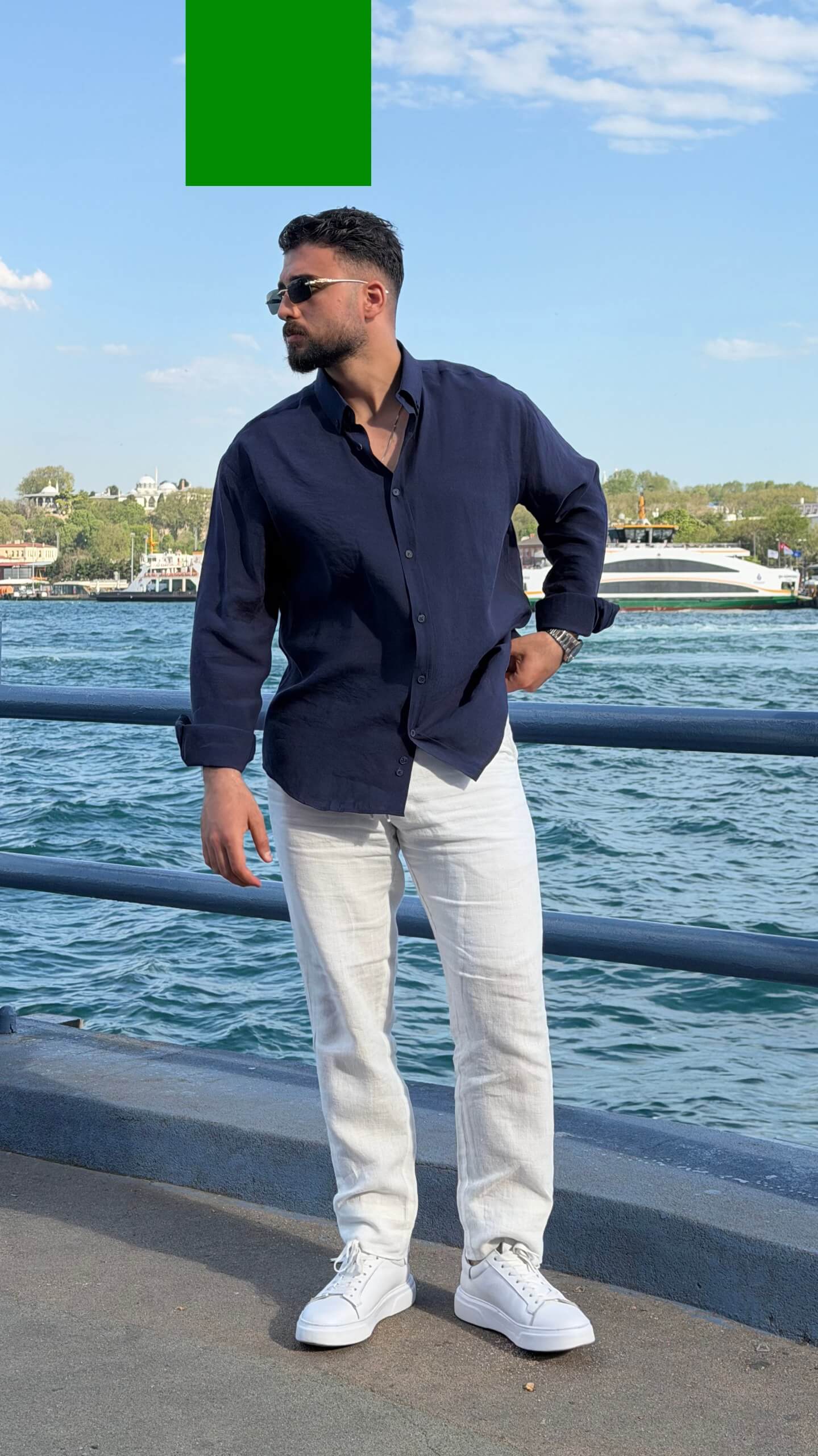 Casual summer look: navy blue oversize shirt with rolled sleeves and white trousers