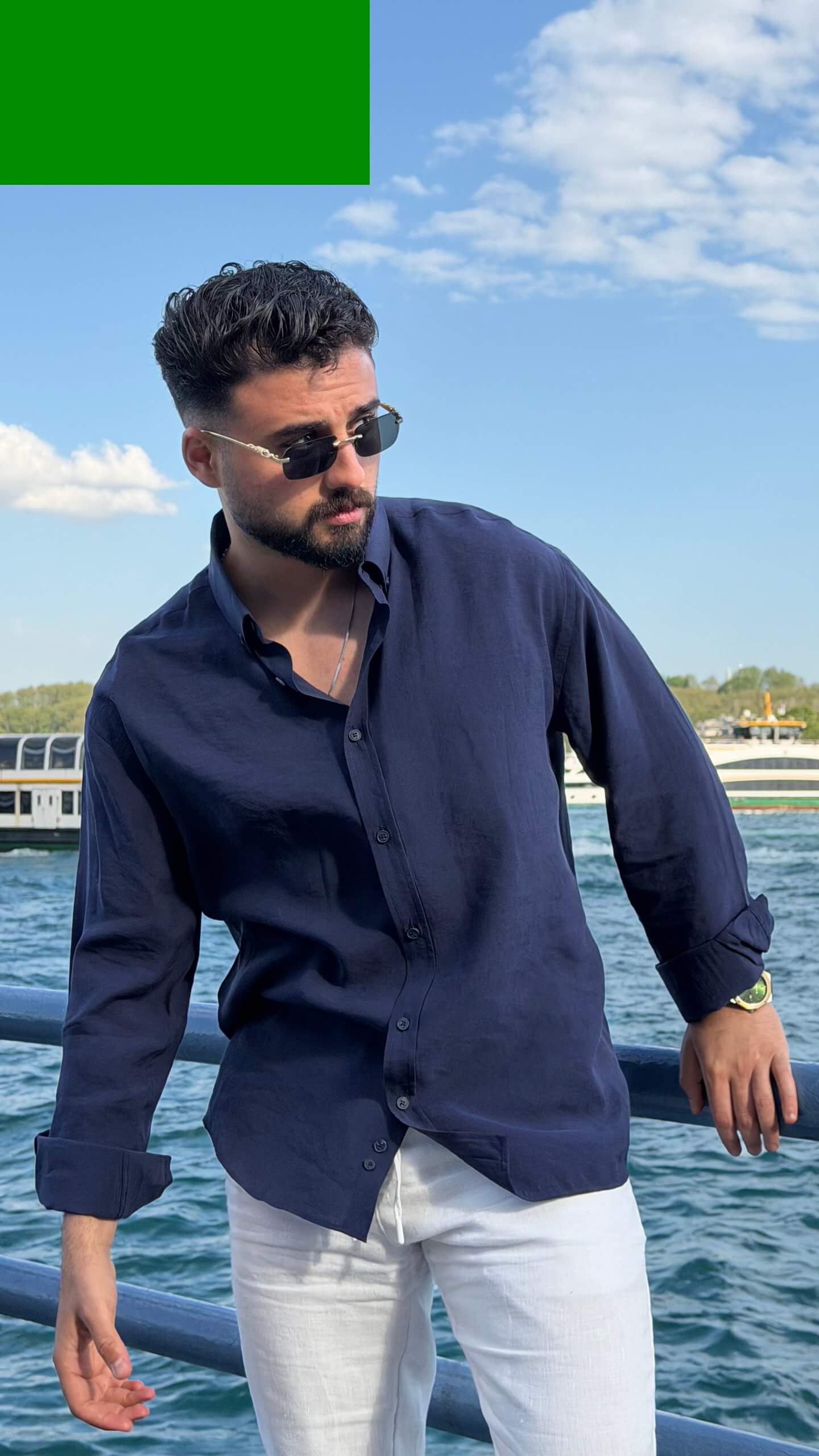 Casual summer look: navy blue oversize shirt with rolled sleeves and white trousers