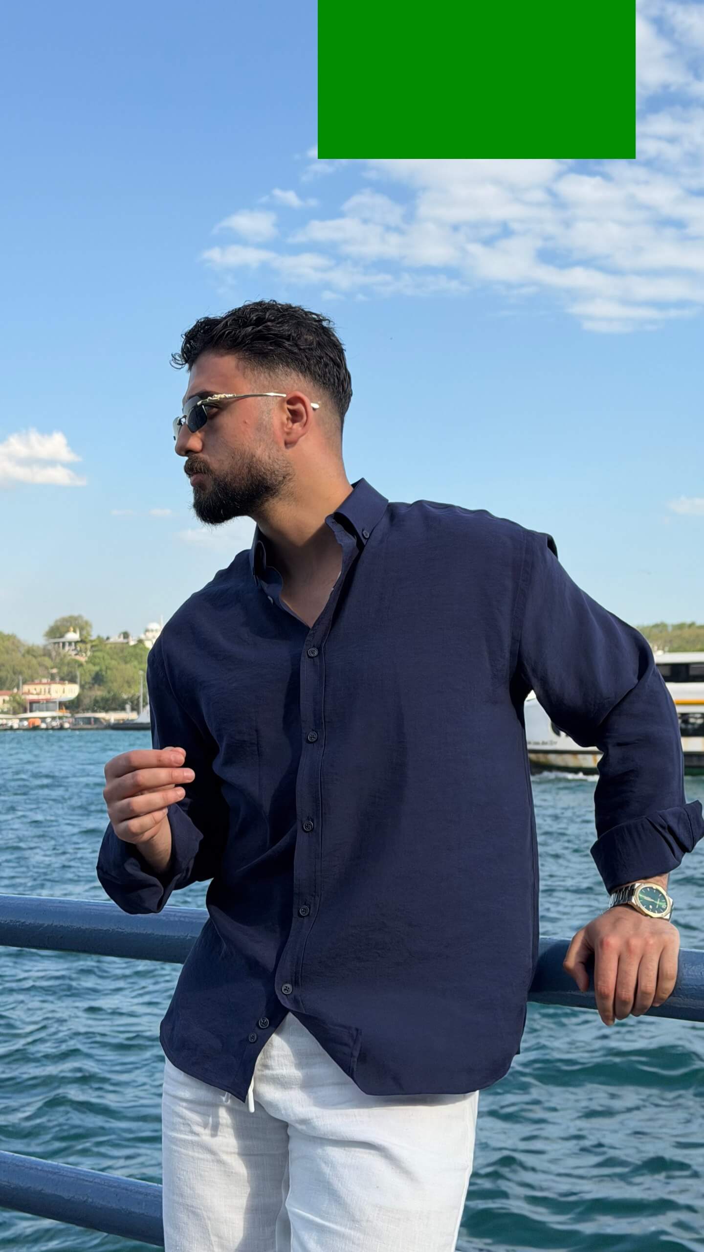 Casual summer look: navy blue oversize shirt with rolled sleeves and white trousers