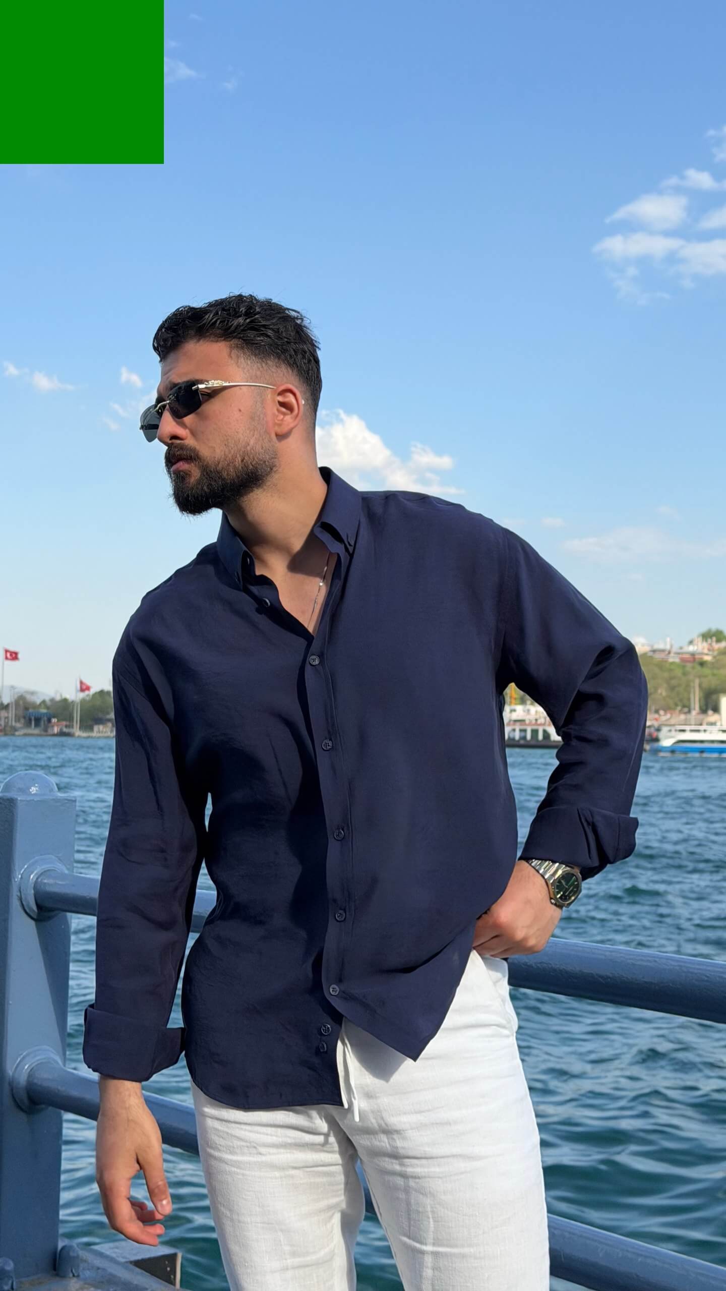 Casual summer look: navy blue oversize shirt with rolled sleeves and white trousers
