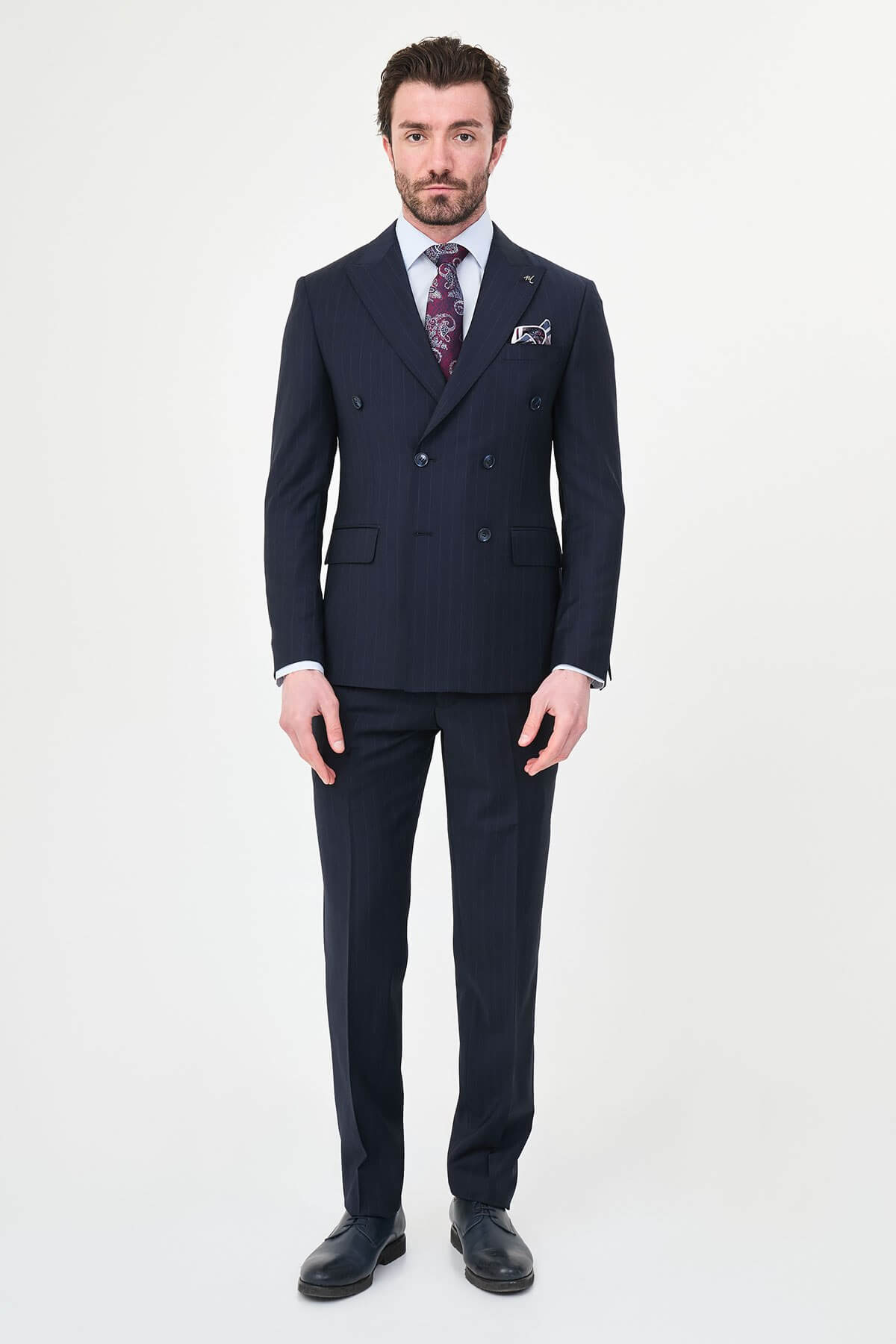 Hollomen Navy Blue Pinstripe Double-Breasted Slim Fit Premium Wool Suit on a male model, styled with a burgundy patterned tie and matching pocket square.