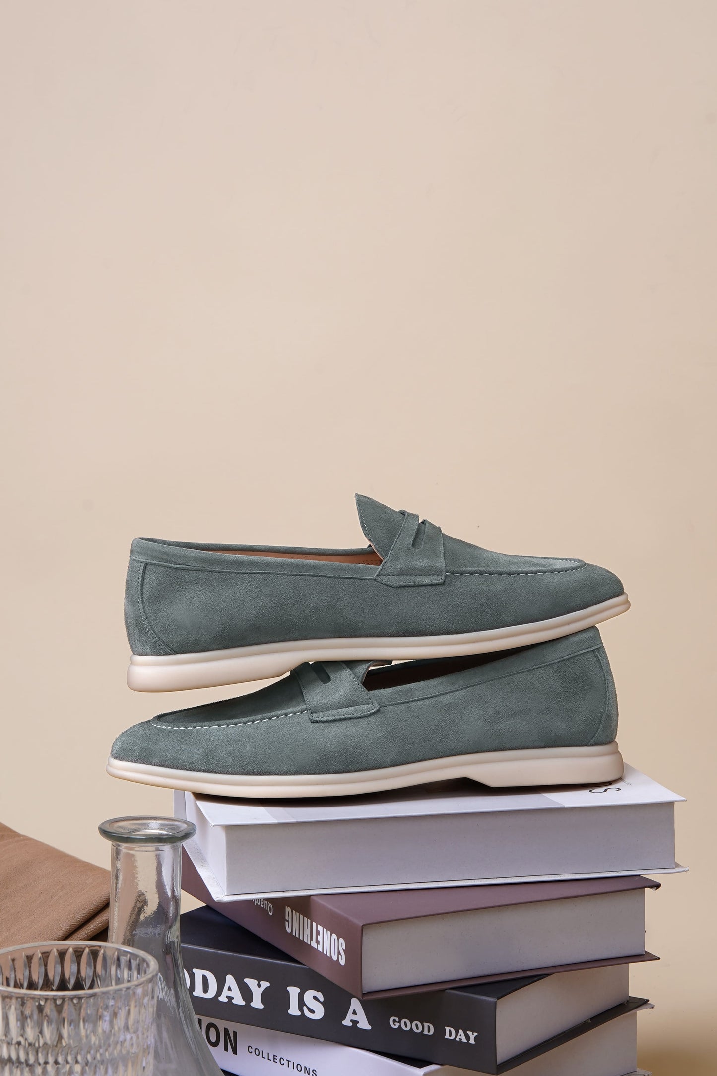 Men’s pale cyan mist suede leather penny loafers with classic strap detail and lightweight cream sole.