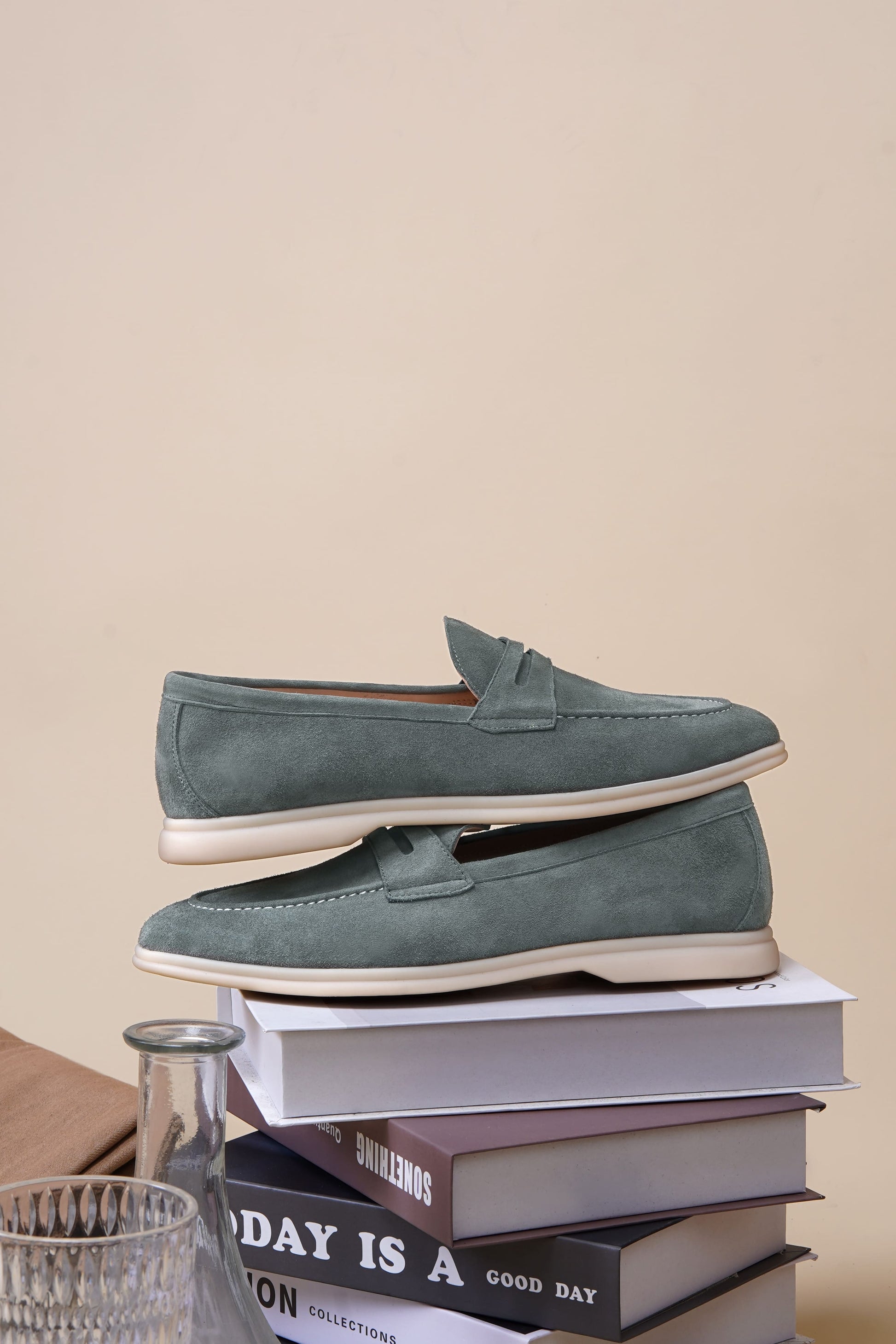 Men’s pale cyan mist suede leather penny loafers with classic strap detail and lightweight cream sole.