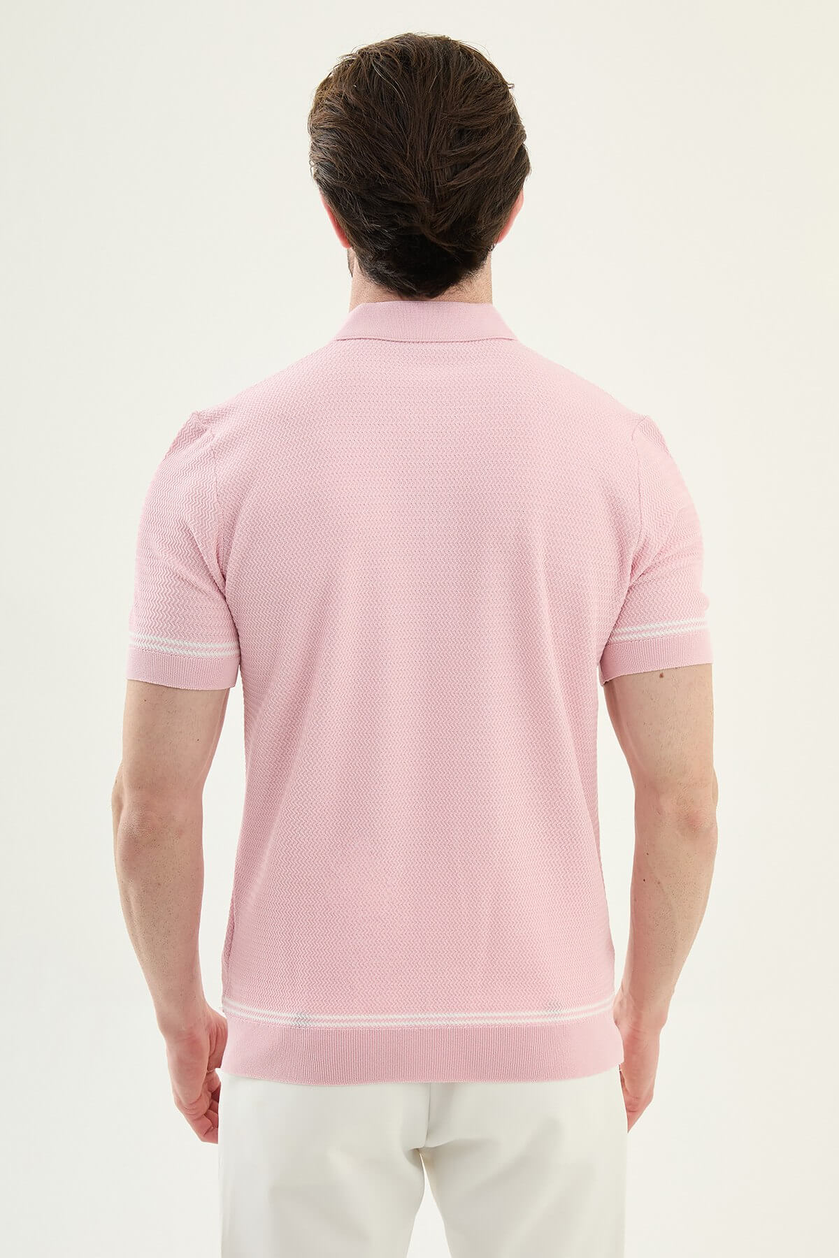Man wearing a pink slim-fit quarter-zip polo T-shirt, short sleeves, standing against a neutral background, styled for summer casual wear.