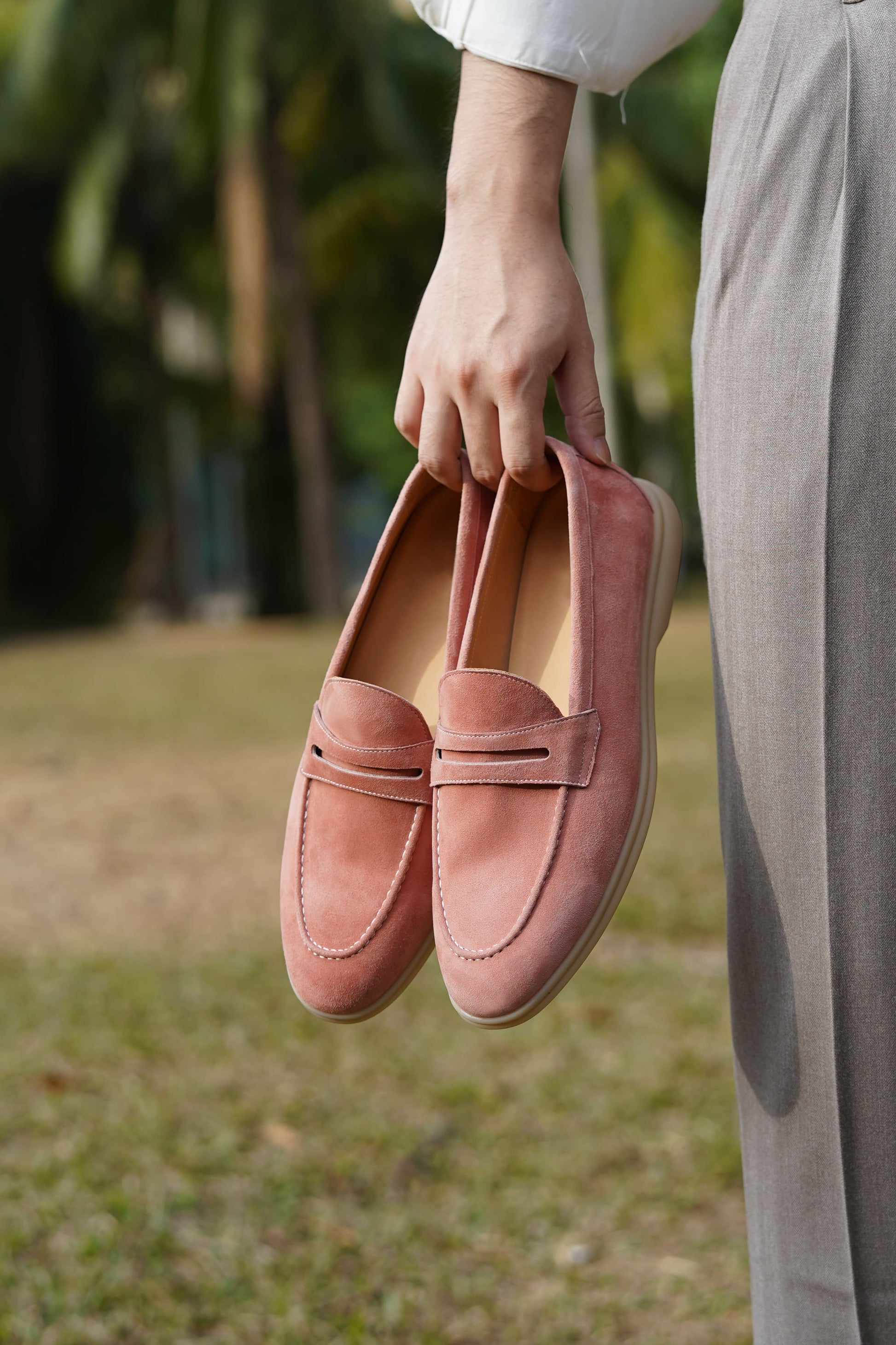 Men’s pink suede leather penny loafers with classic vamp strap detail and lightweight sole.