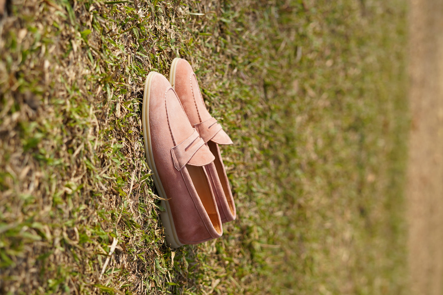 Men’s pink suede leather penny loafers with classic vamp strap detail and lightweight sole.