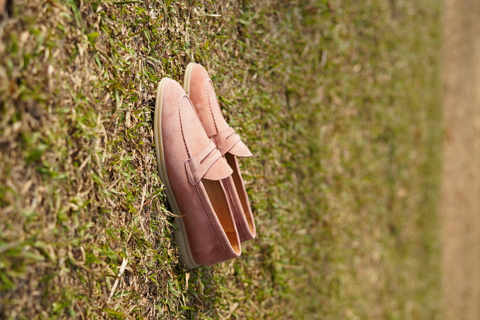 Men’s pink suede leather penny loafers with classic vamp strap detail and lightweight sole.