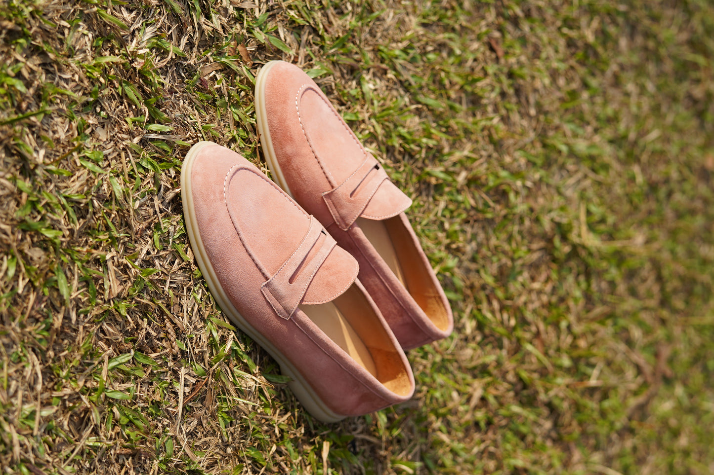 Men’s pink suede leather penny loafers with classic vamp strap detail and lightweight sole.