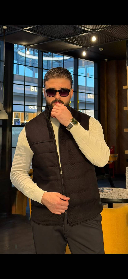 Men’s black zip-up vest with slim fit design styled over a cream sweater for fall winter layering