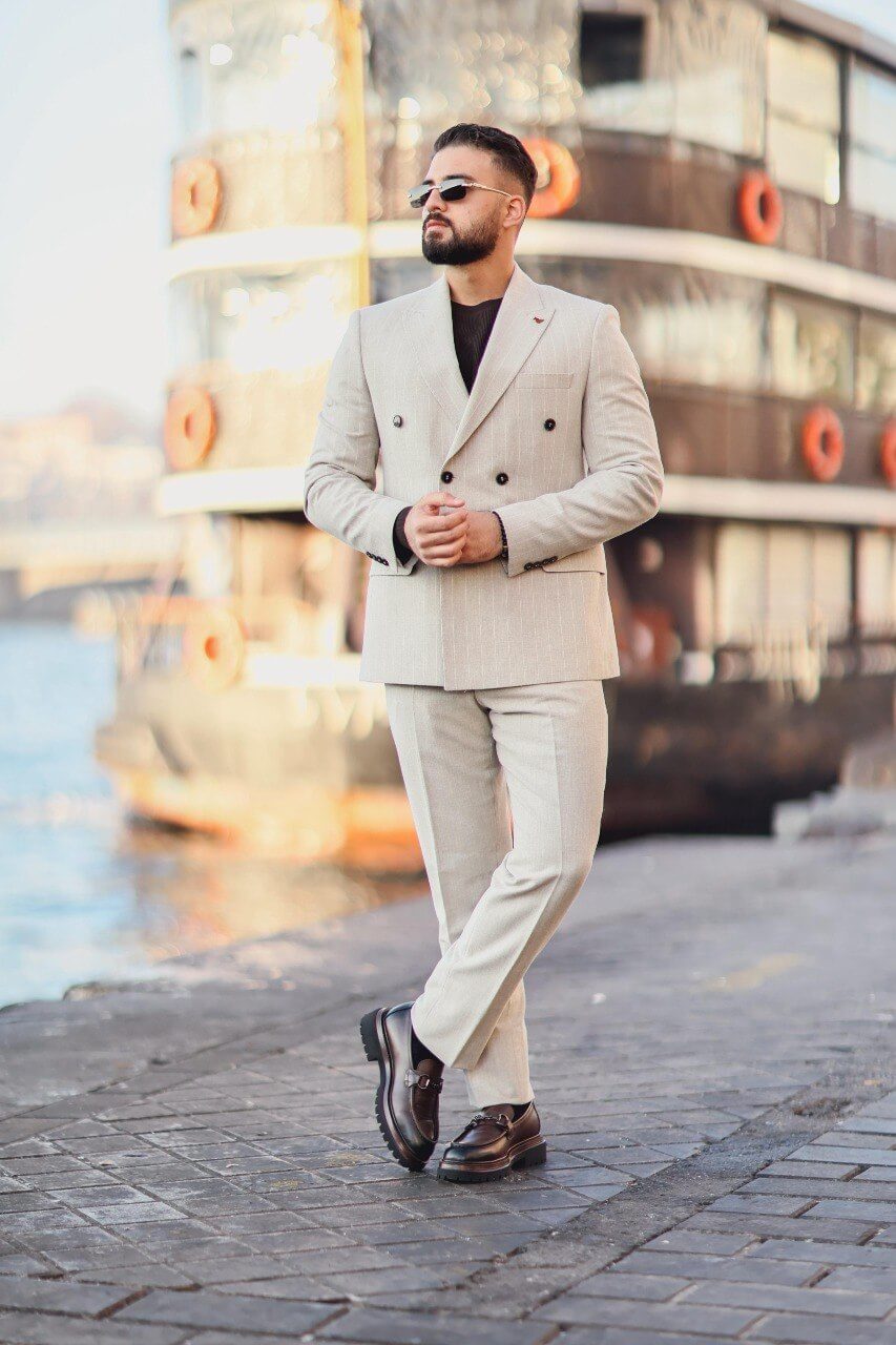 Men’s beige double-breasted pinstripe slim-fit suit styled with dark knit top