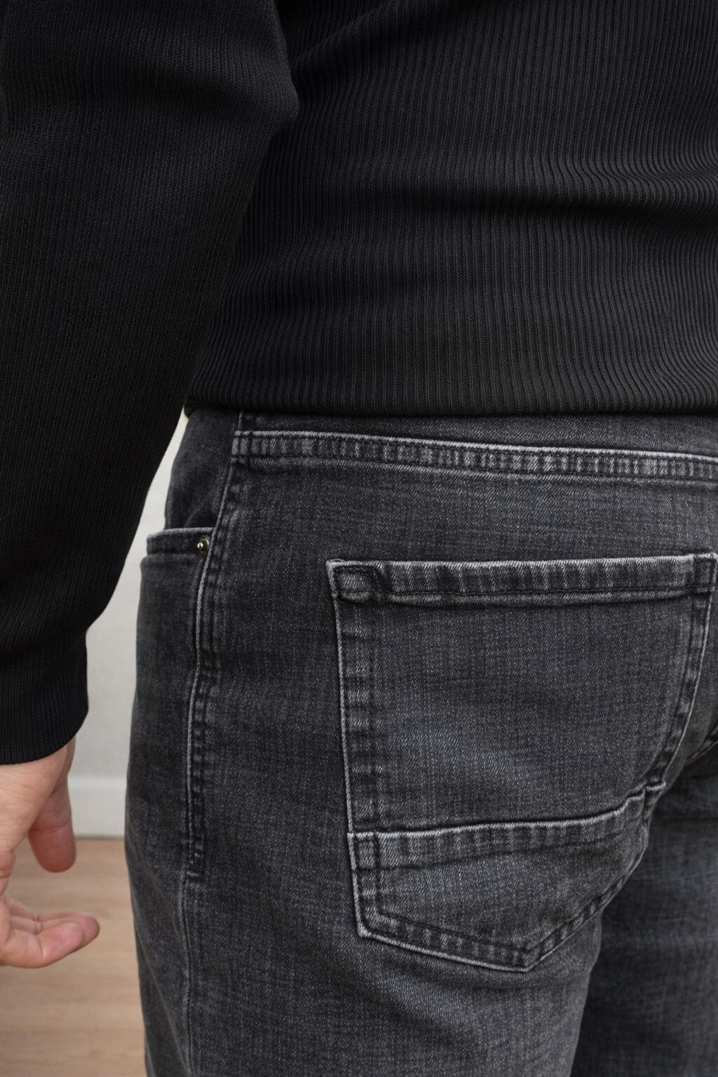 Black slim straight men’s jeans styled with black sweater and loafers