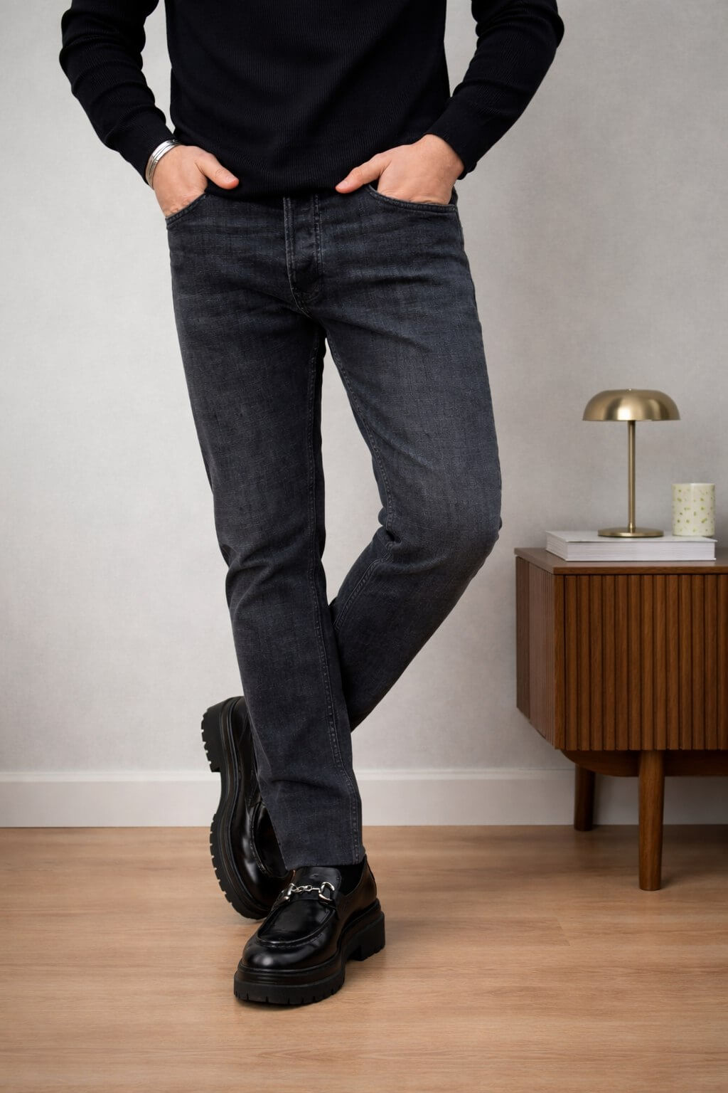 Black slim straight men’s jeans styled with black sweater and loafers