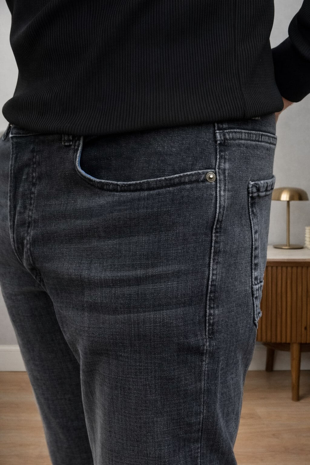 Black slim straight men’s jeans styled with black sweater and loafers