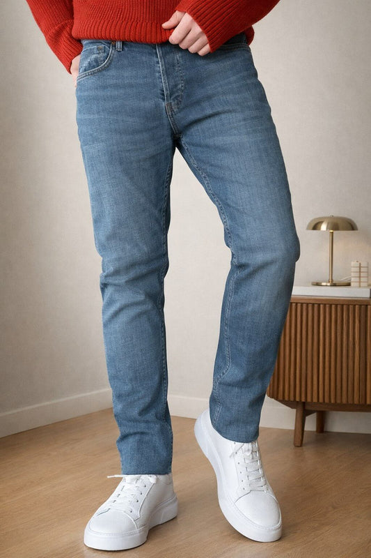 Blue slim straight men’s jeans styled with red knit sweater and white sneakers