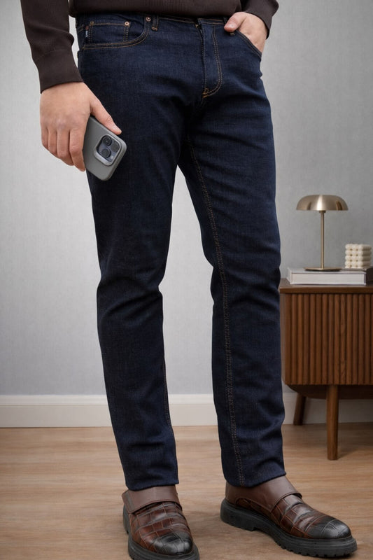 Dark blue slim straight men’s jeans styled with brown knit sweater and leather loafers