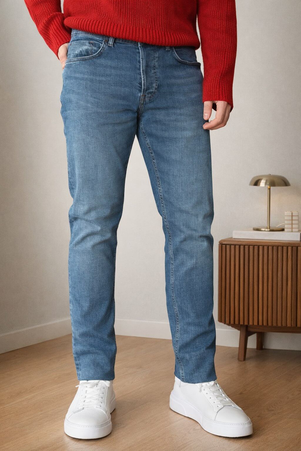Blue slim straight men’s jeans styled with red knit sweater and white sneakers