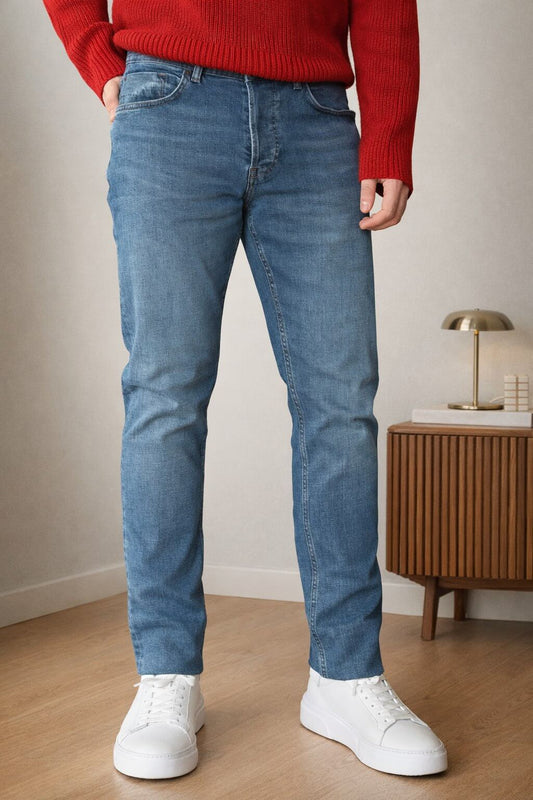 Blue slim straight men’s jeans styled with red knit sweater and white sneakers