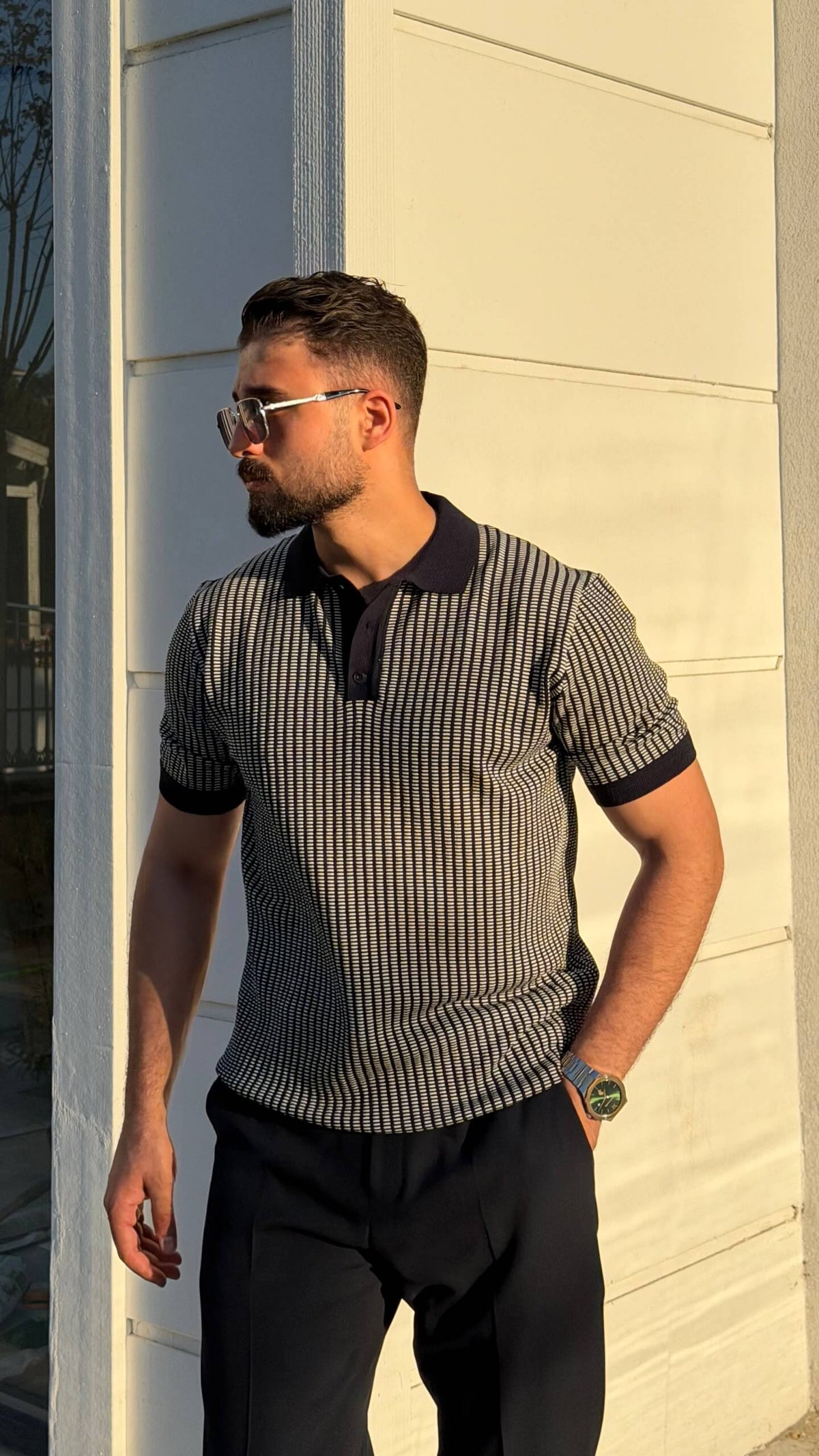 Men’s khaki textured short sleeve knit polo shirt with contrast collar styled with black trousers